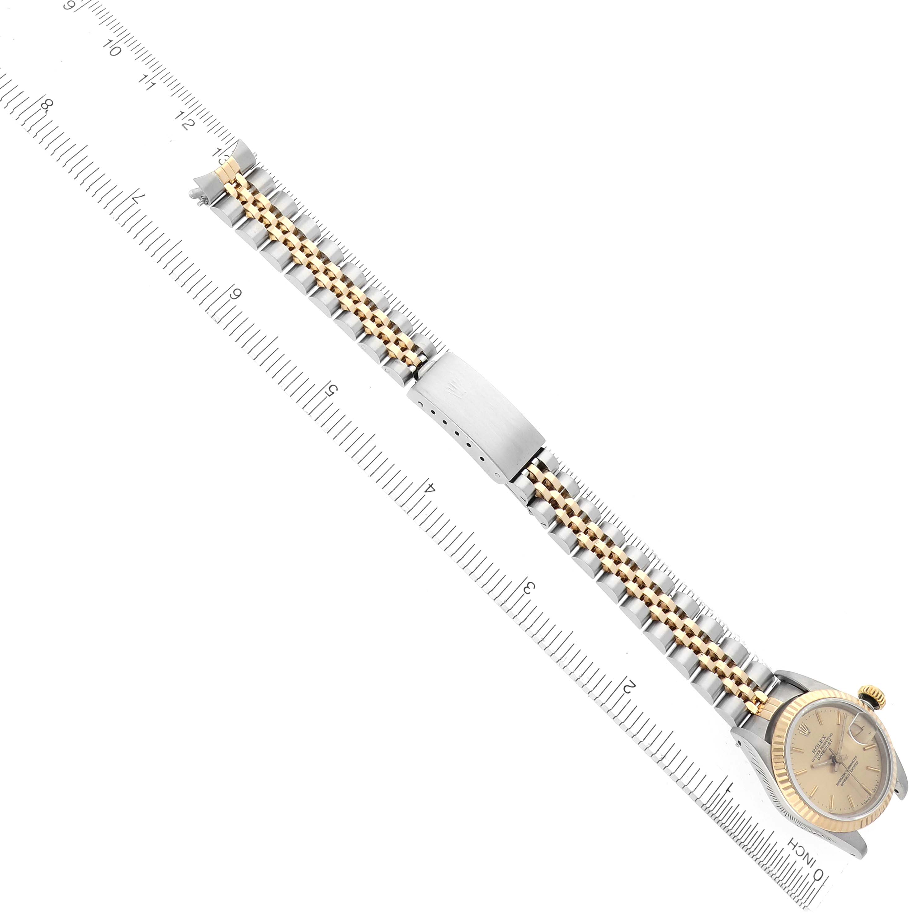The image shows a Rolex Datejust 69173 Women's Steel and Gold (two tone) Champagne Dial 69173 Women's Steel and Gold (two tone) Champagne Dial watch laid flat, highlighting its bracelet and face alongside a ruler for scale.