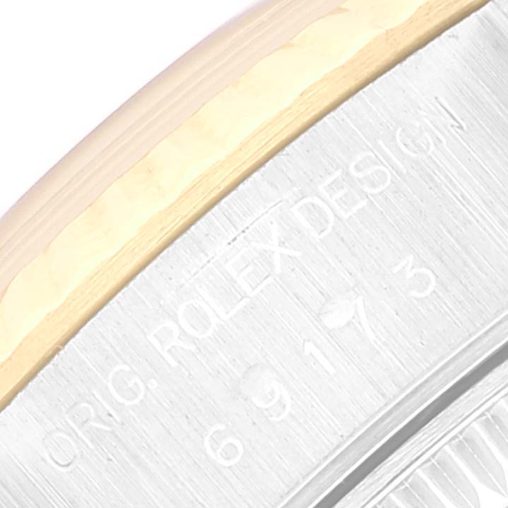 This image shows a close-up angle of the model and serial numbers engraved on the side of a Rolex Datejust 69173 Women's Steel and Gold (two tone) Champagne Dial 69173 Women's Steel and Gold (two tone) Champagne Dial watch case.