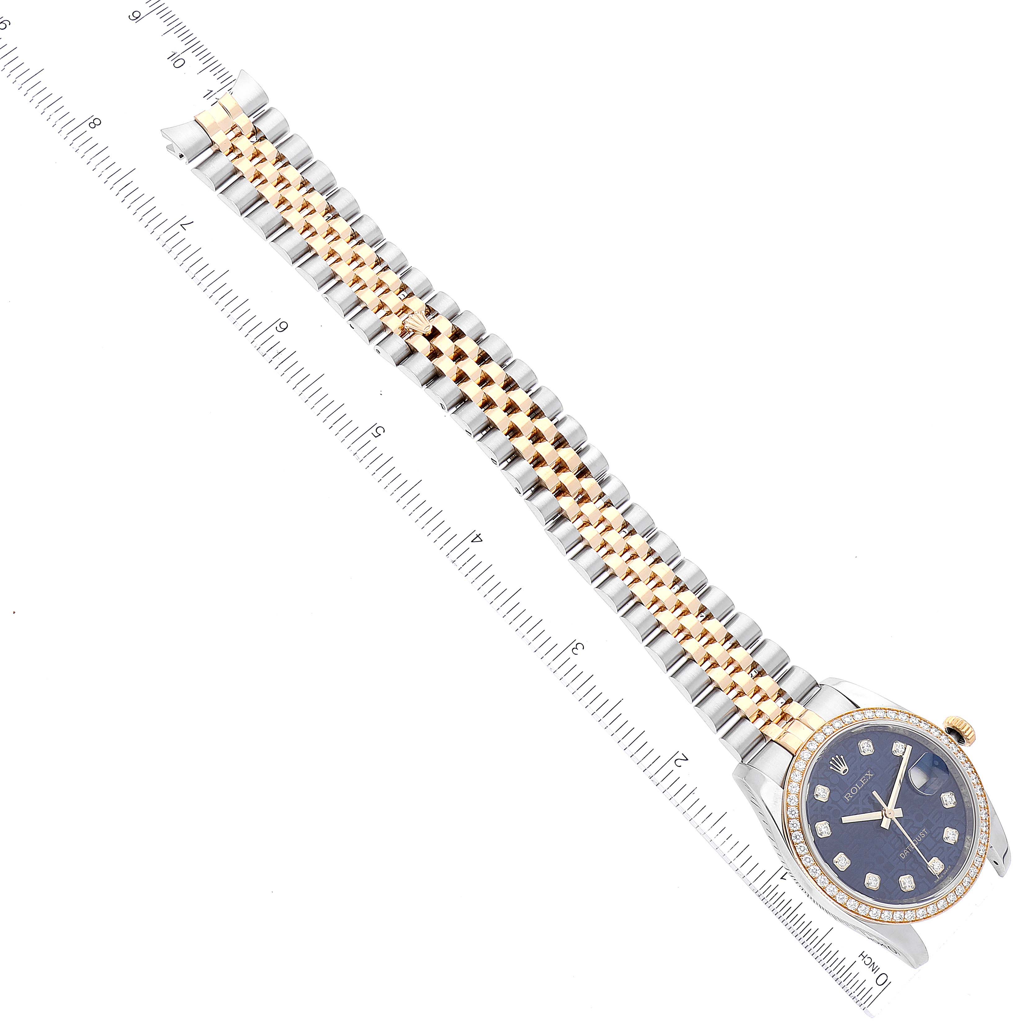 The Rolex Datejust 116243 Men's Steel and Gold (two tone) Blue Dial 116243 Men's Steel and Gold (two tone) Blue Dial watch is shown from an overhead angle, featuring its full band and face with a ruler for scale.