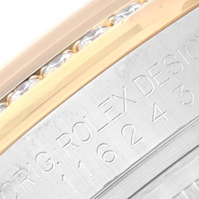 This image shows a close-up angle of the bezel and case side of a Rolex Datejust 116243 Men's Steel and Gold (two tone) Blue Dial 116243 Men's Steel and Gold (two tone) Blue Dial model watch, with visible engraved text.