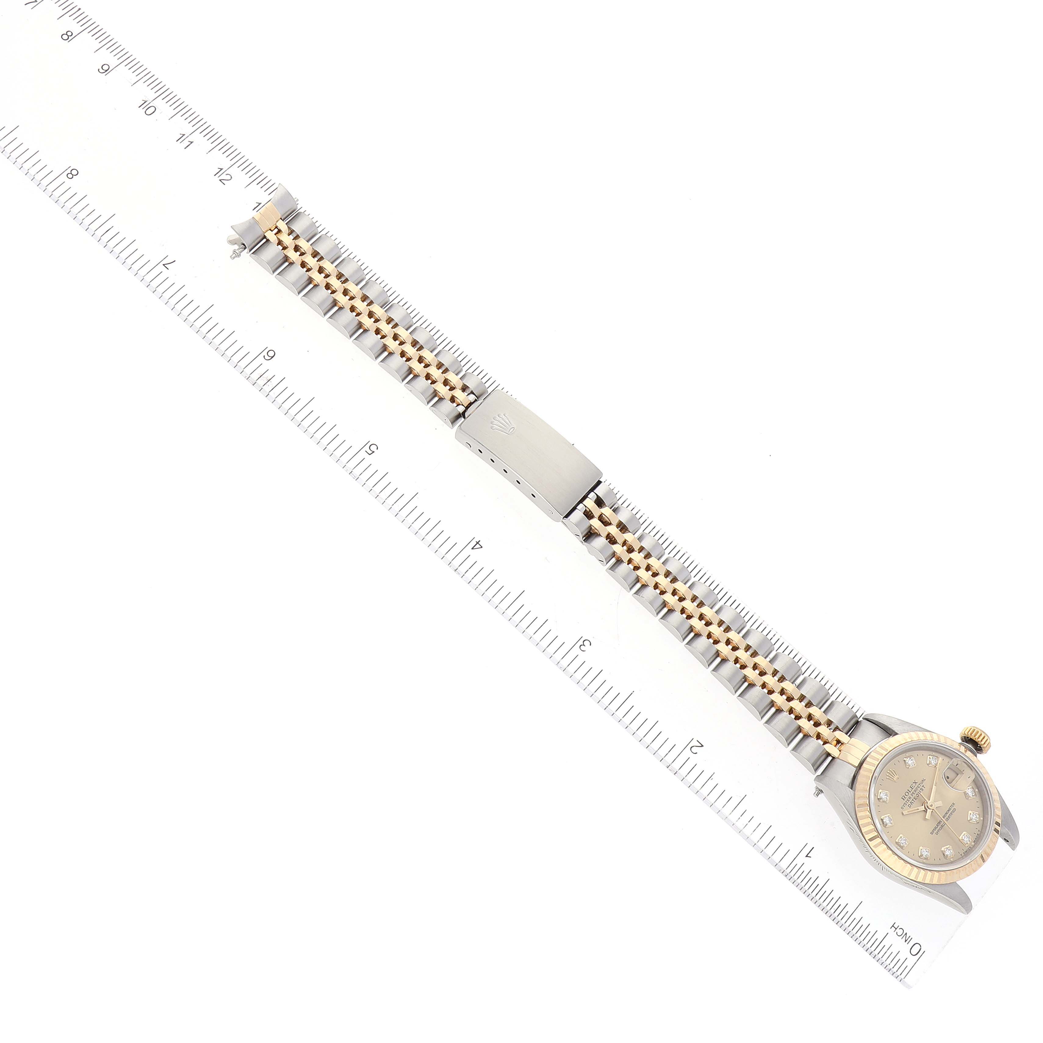This image shows the Rolex Datejust 69173 Women's Steel and Gold (two tone) Champagne Dial 69173 Women's Steel and Gold (two tone) Champagne Dial watch flat and fully extended, displaying the face, bezel, and bracelet with a ruler for scale.