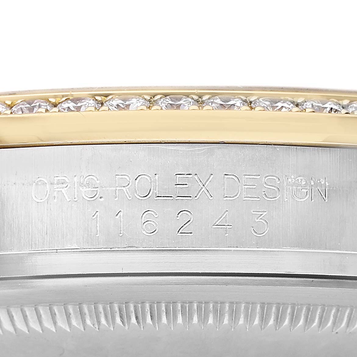The image shows a close-up of the Rolex Datejust 116243 Men's Steel and Gold (two tone) Silver Dial's bezel with diamond accents and engraved serial number.