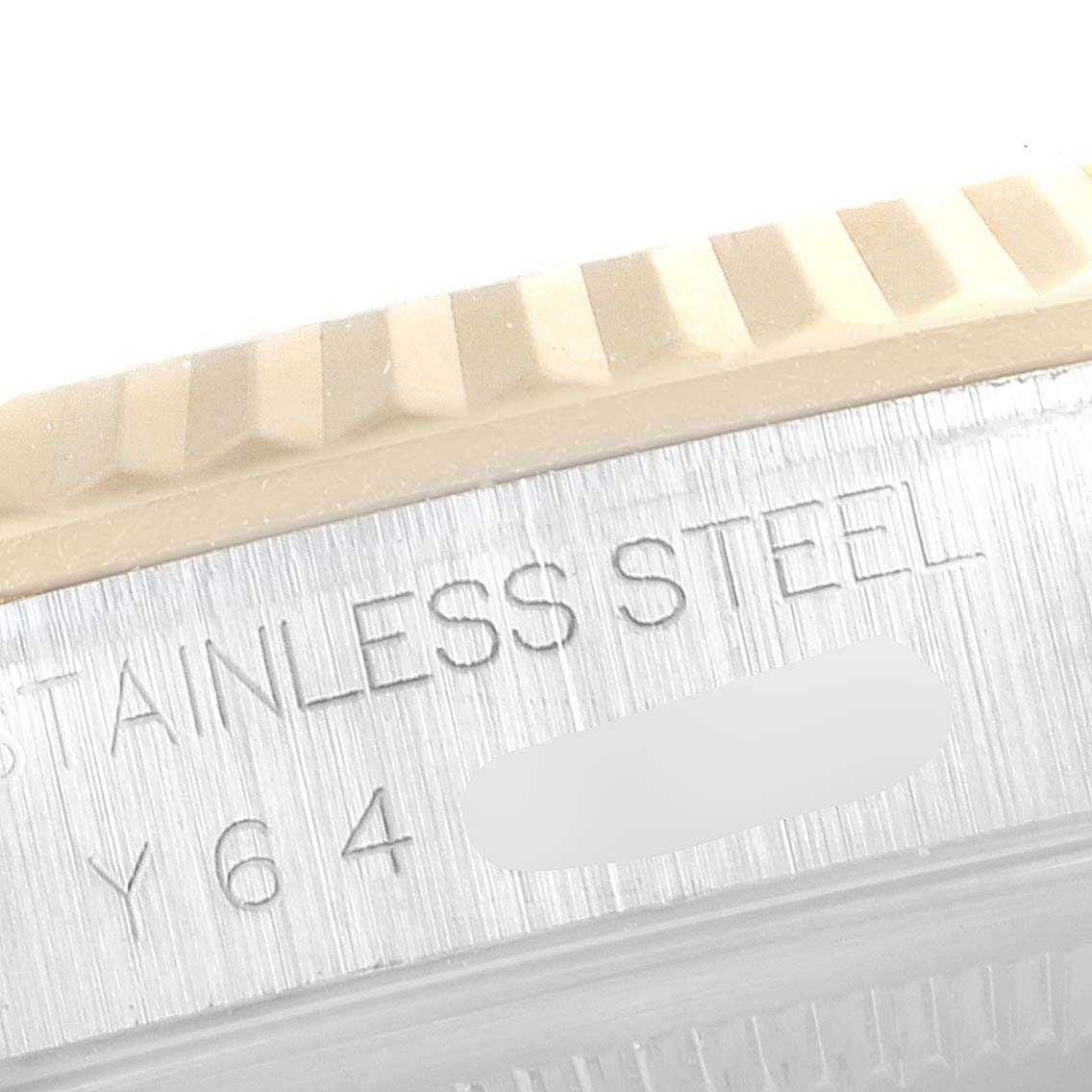 This close-up image shows the stainless steel fluted bezel and case edge with engraving on a Rolex Datejust 16233 Men's Steel and Gold (two tone) Silver Dial 16233 Men's Steel and Gold (two tone) Silver Dial watch.