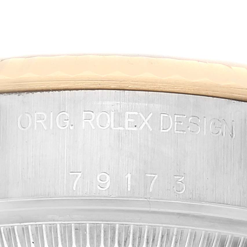 The image shows a close-up of the side of a Rolex Datejust 79173 Women's Steel and Gold (two tone) White Dial 79173 Women's Steel and Gold (two tone) White Dial watch case with engraved text and model number.
