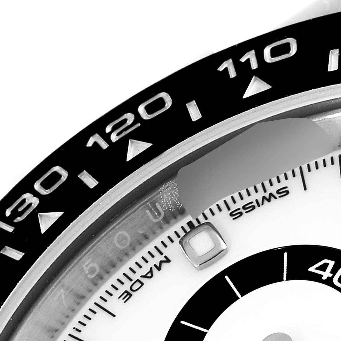 This is a close-up of a Rolex Daytona 116500 Men's Stainless Steel White Dial 116500 Men's Stainless Steel White Dial watch, showing part of the bezel and the Swiss Made marking on the dial.