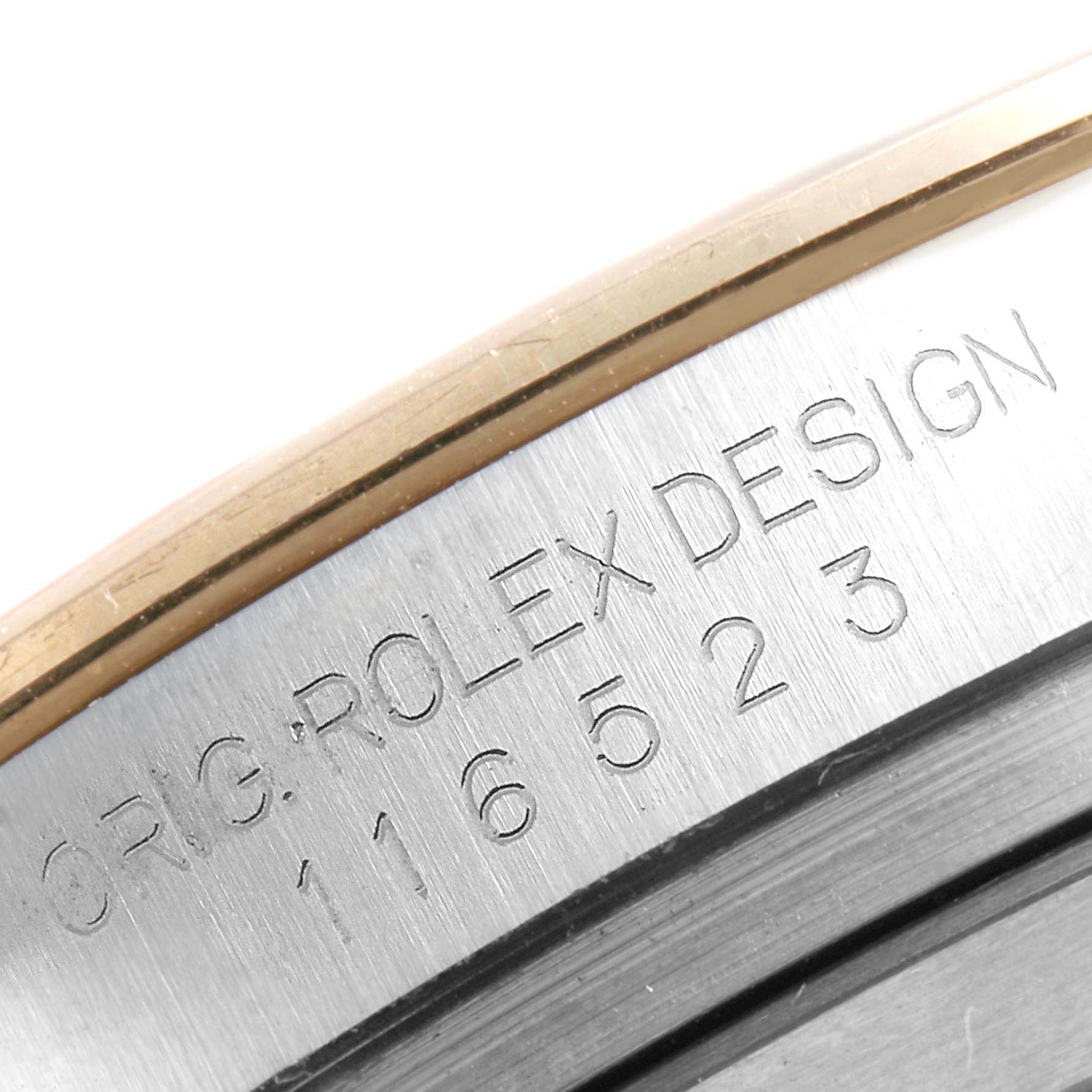The image shows an angled close-up of the case side of a Rolex Daytona 116523 Men
s Steel and Gold (two tone) Blue Dial 116523 Men
s Steel and Gold (two tone) Blue Dial, highlighting the engraved serial number.