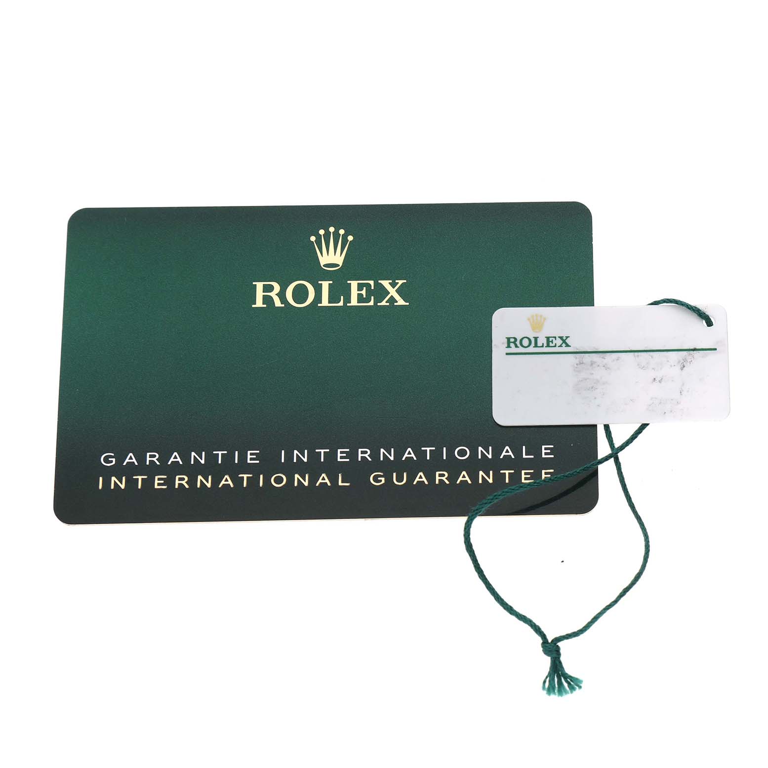 The image shows a Rolex Explorer 216570 Men's Stainless Steel Black Dial international guarantee card and a tag with the Rolex logo.