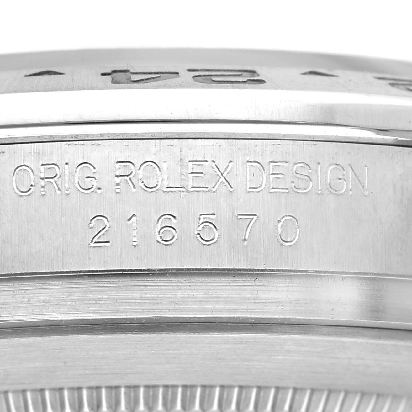 The image shows a close-up of the side of a Rolex Explorer 216570 Men's Stainless Steel Black Dial watch, revealing the engraved "ORIG. ROLEX DESIGN 216570."