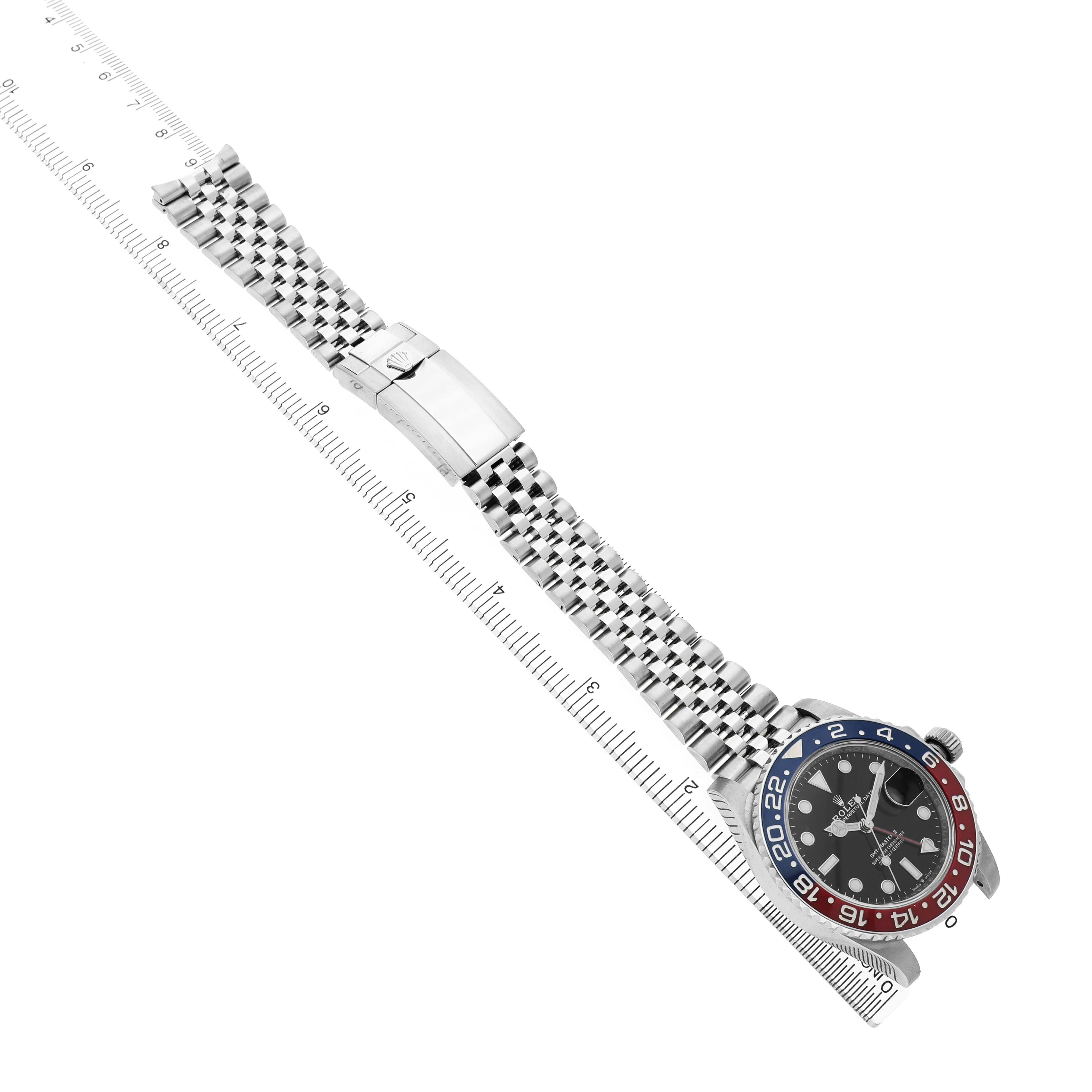 The image shows a Rolex GMT-Master 126710 Men's Stainless Steel Black Dial watch at an angled view, displaying the bezel, dial, bracelet, and clasp alongside a ruler.