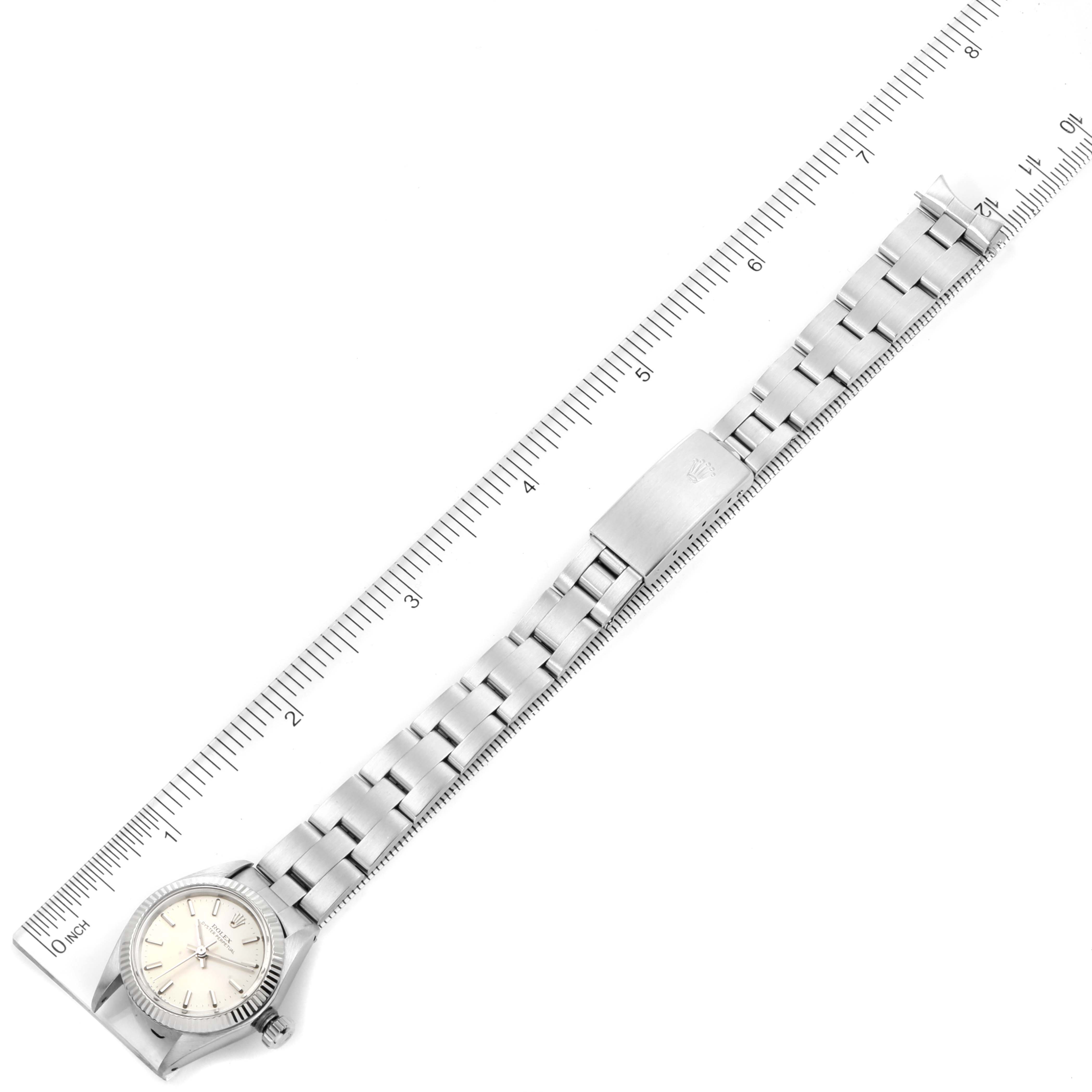 The image shows a Rolex Oyster Perpetual 6719 Women's Stainless Steel Silver Dial 6719 Women's Stainless Steel Silver Dial watch laid flat next to a ruler, with the full bracelet and face visible.