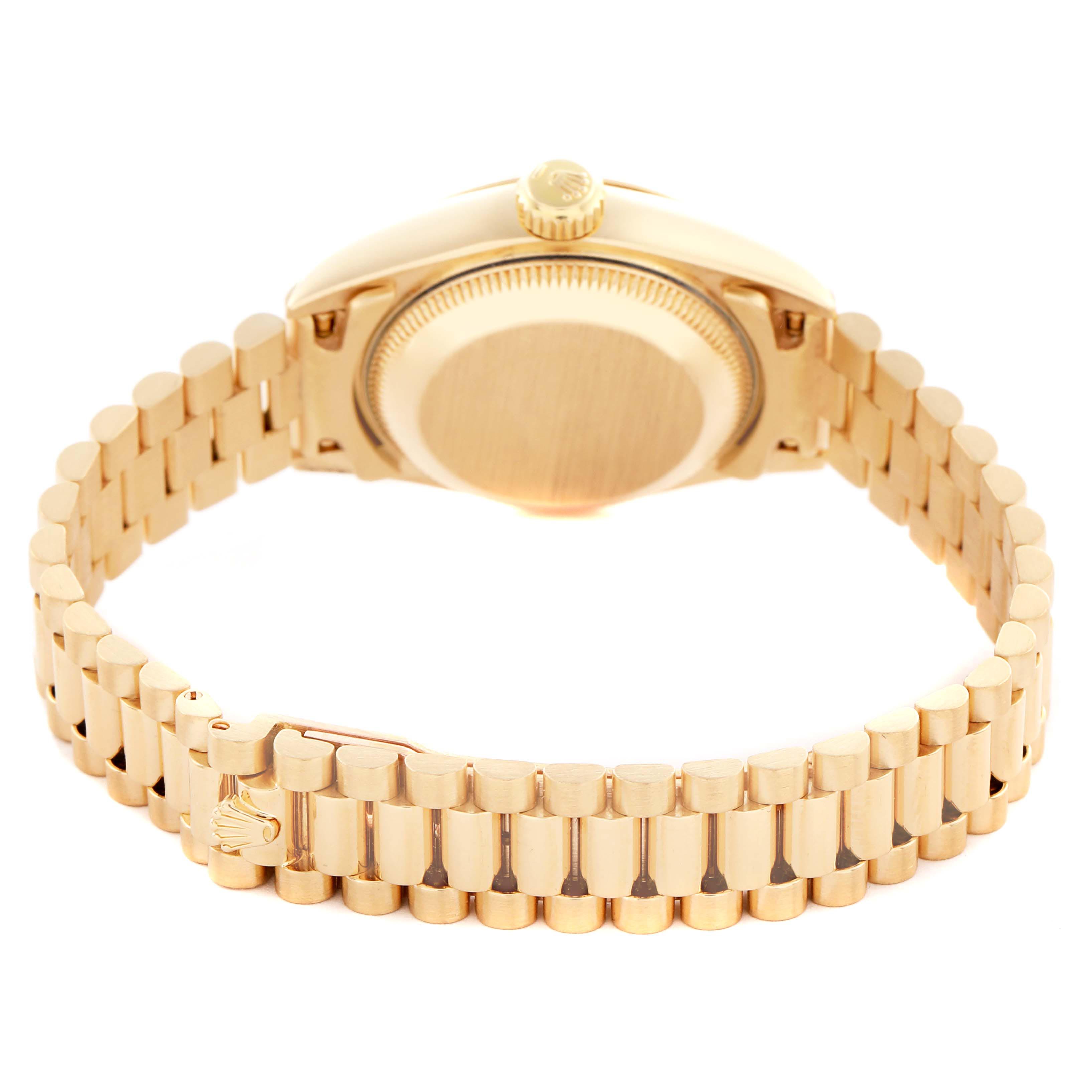 The image shows the backside of a Rolex President 69178 Women's Yellow Gold Champagne Dial 69178 Women's Yellow Gold Champagne Dial watch, highlighting the gold case and bracelet with the clasp visible.