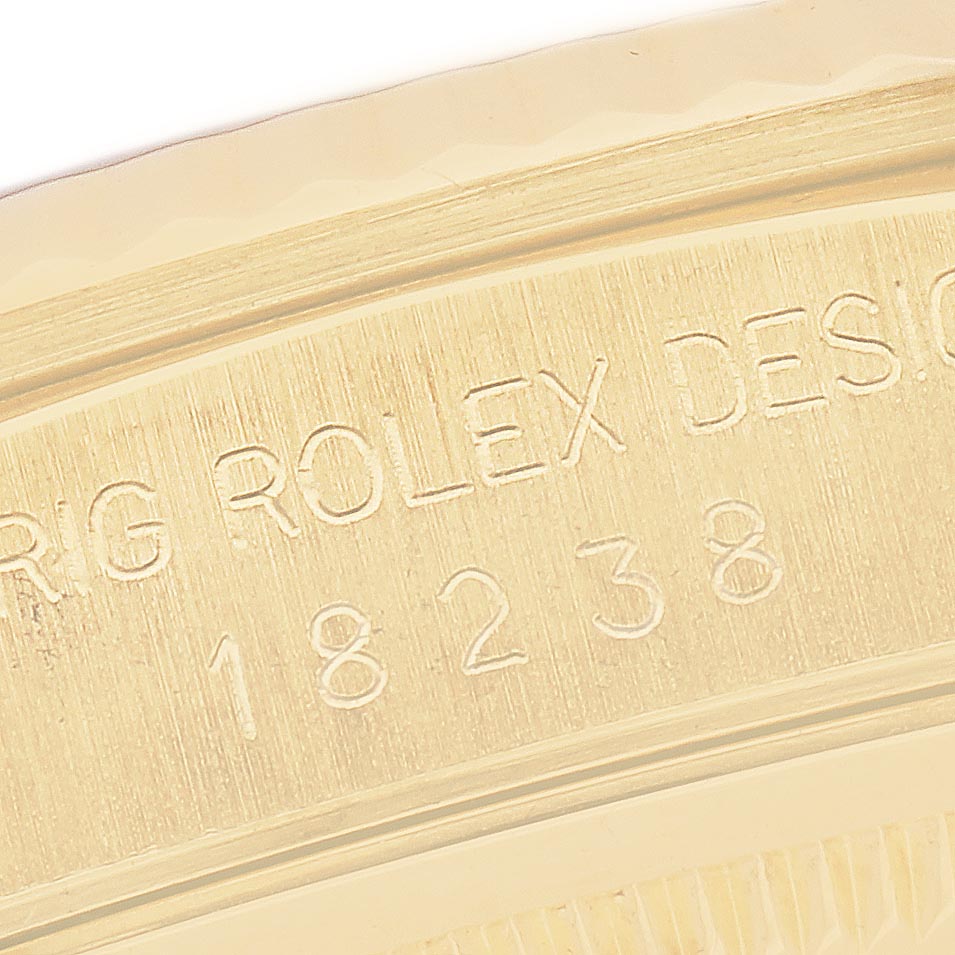 The image shows a close-up of the engraved side of a Rolex President 18238 Men
s Yellow Gold Champagne Dial 18238 Men
s Yellow Gold Champagne Dial model, featuring its serial number and branding.