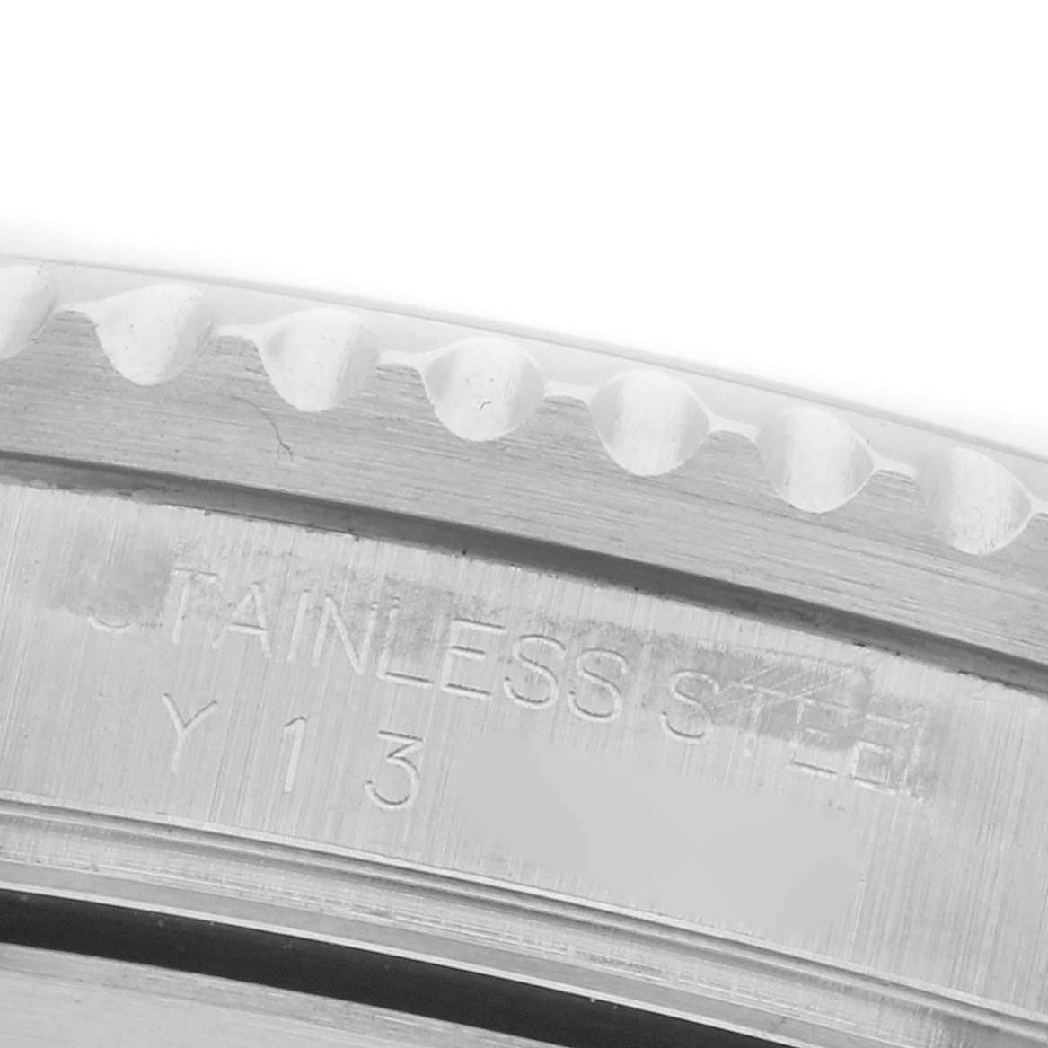 The image shows a close-up of the edge of the bezel and engraved case back of a Rolex Submariner 16610 Men's Stainless Steel Black Dial 16610 Men's Stainless Steel Black Dial.