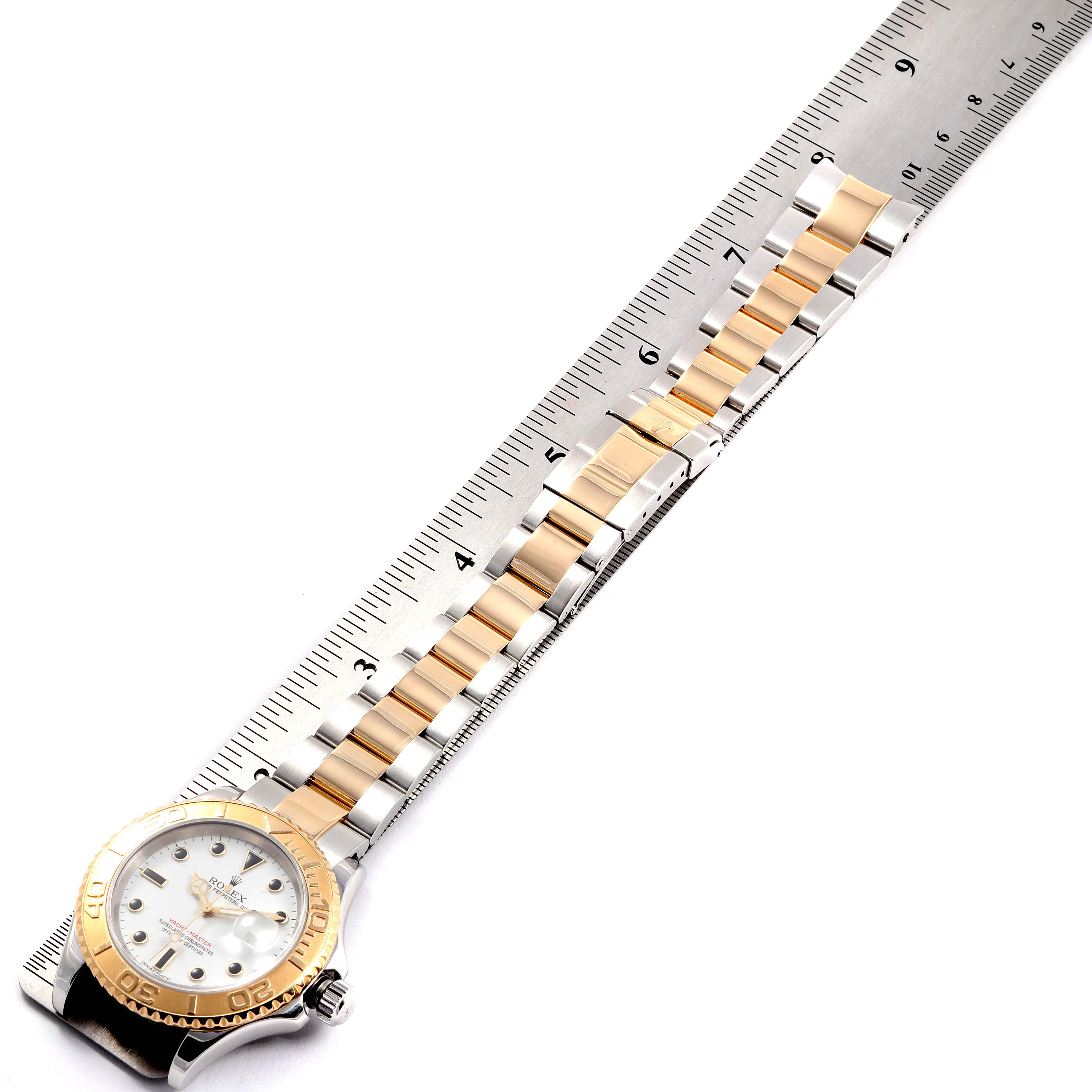 The image shows a top-down view of a Rolex Yacht-Master 16623 Men's Steel and Gold (two tone) White Dial 16623 Men's Steel and Gold (two tone) White Dial watch, focusing on the watch face and bracelet beside a ruler.
