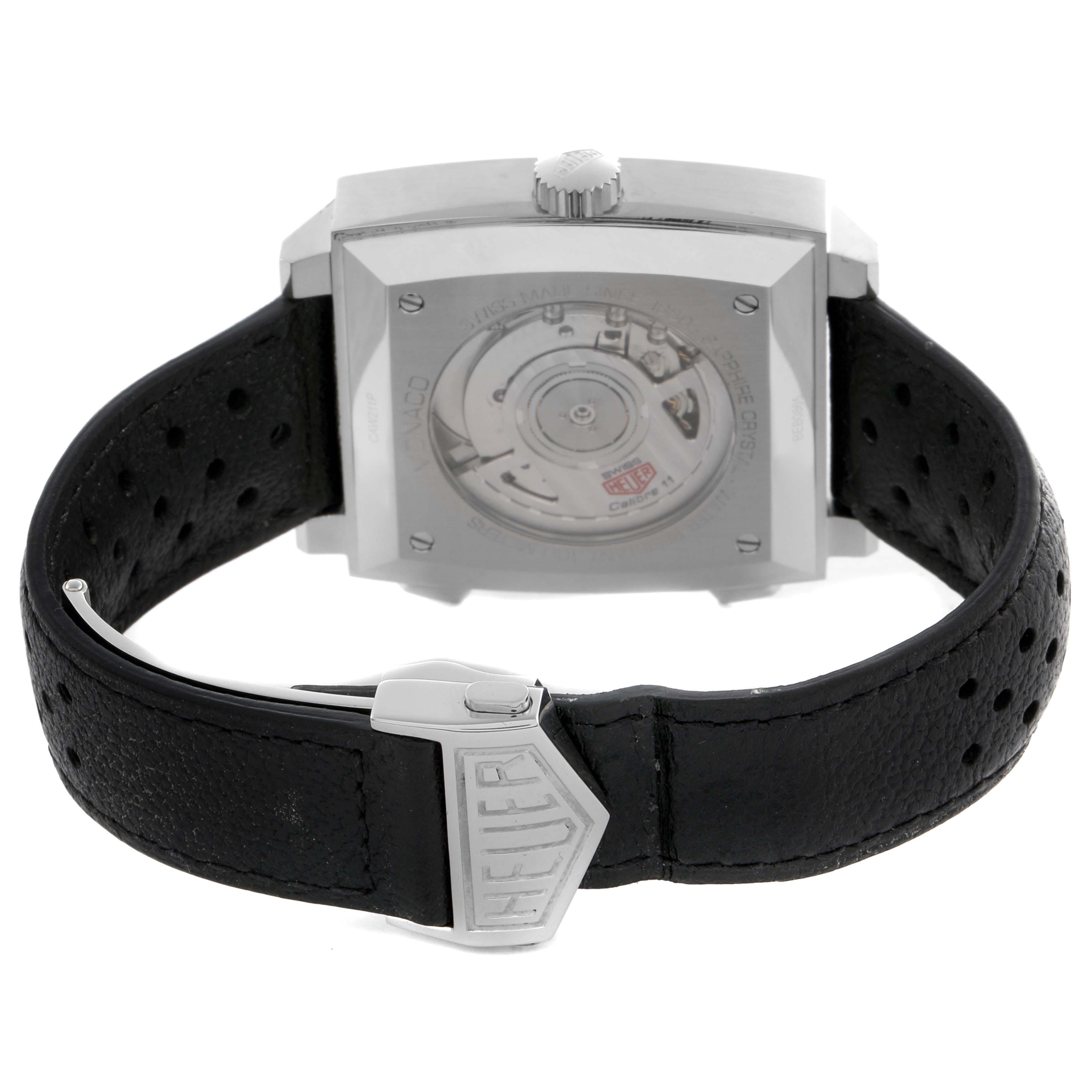 The image shows the back view of a Tag Heuer Monaco CAW211P.FC6356 Men's Stainless Steel Blue Dial CAW211P.FC6356 Men's Stainless Steel Blue Dial watch, displaying its transparent case back and black leather strap with a clasp.