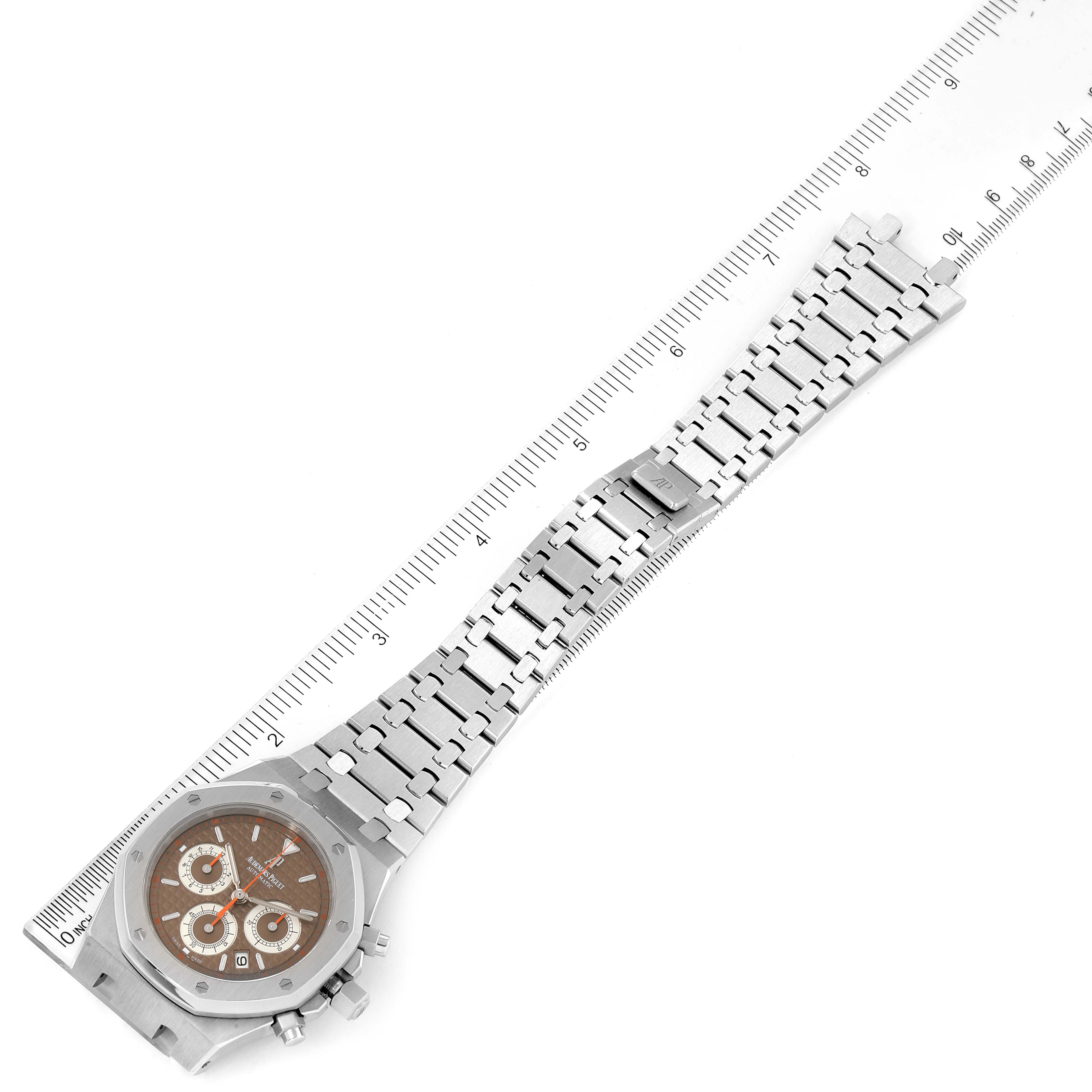 The image shows a top-view angle of an Audemars Piguet Royal Oak 26300ST.OO.1110ST.08 Men's Stainless Steel Brown Dial 26300ST.OO.1110ST.08 Men's Stainless Steel Brown Dial watch, highlighting its face and linked bracelet alongside a ruler.