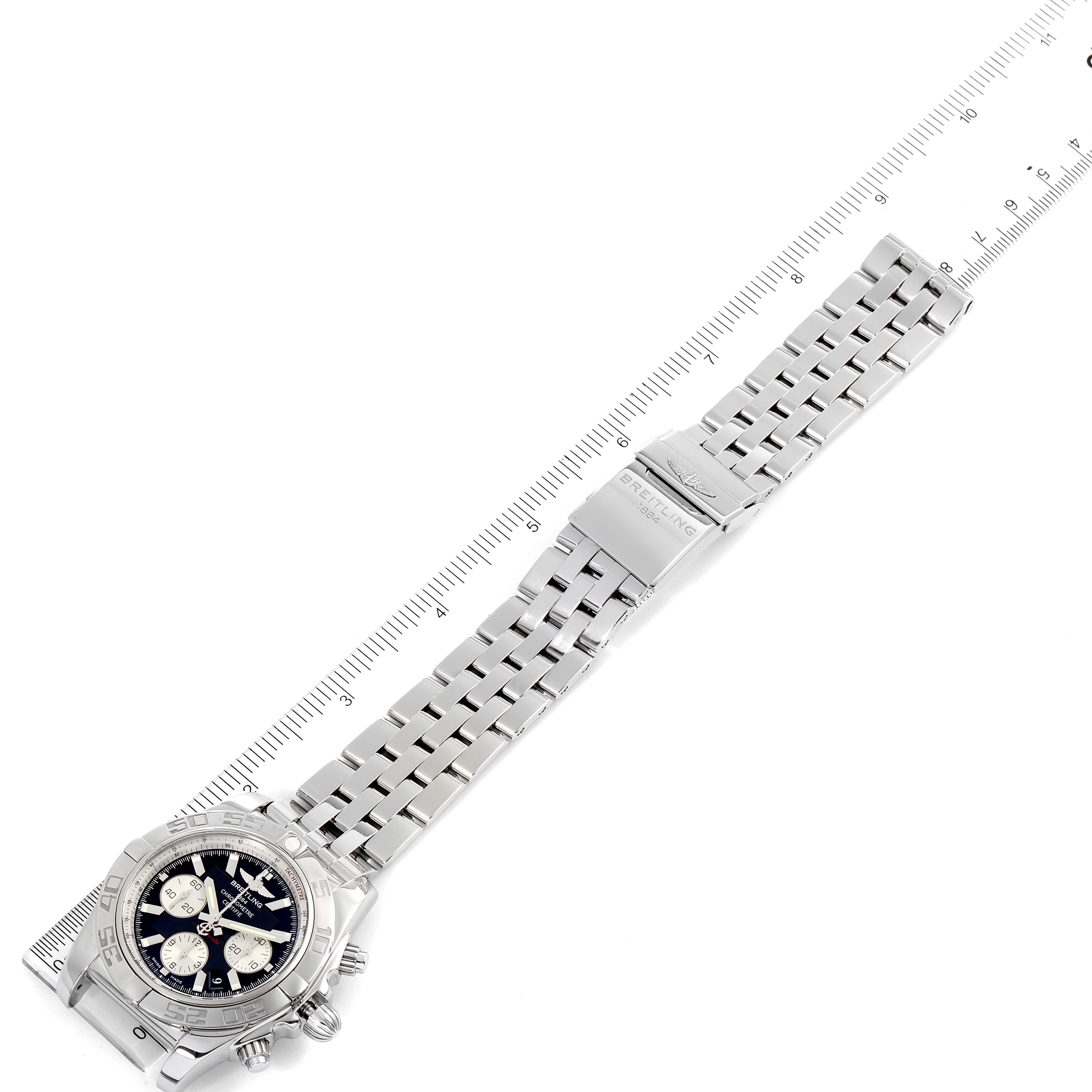 The image shows a Breitling Chronomat AB0110 Men's Stainless Steel Black Dial AB0110 Men's Stainless Steel Black Dial watch flat with its bracelet extended next to a ruler for size reference.