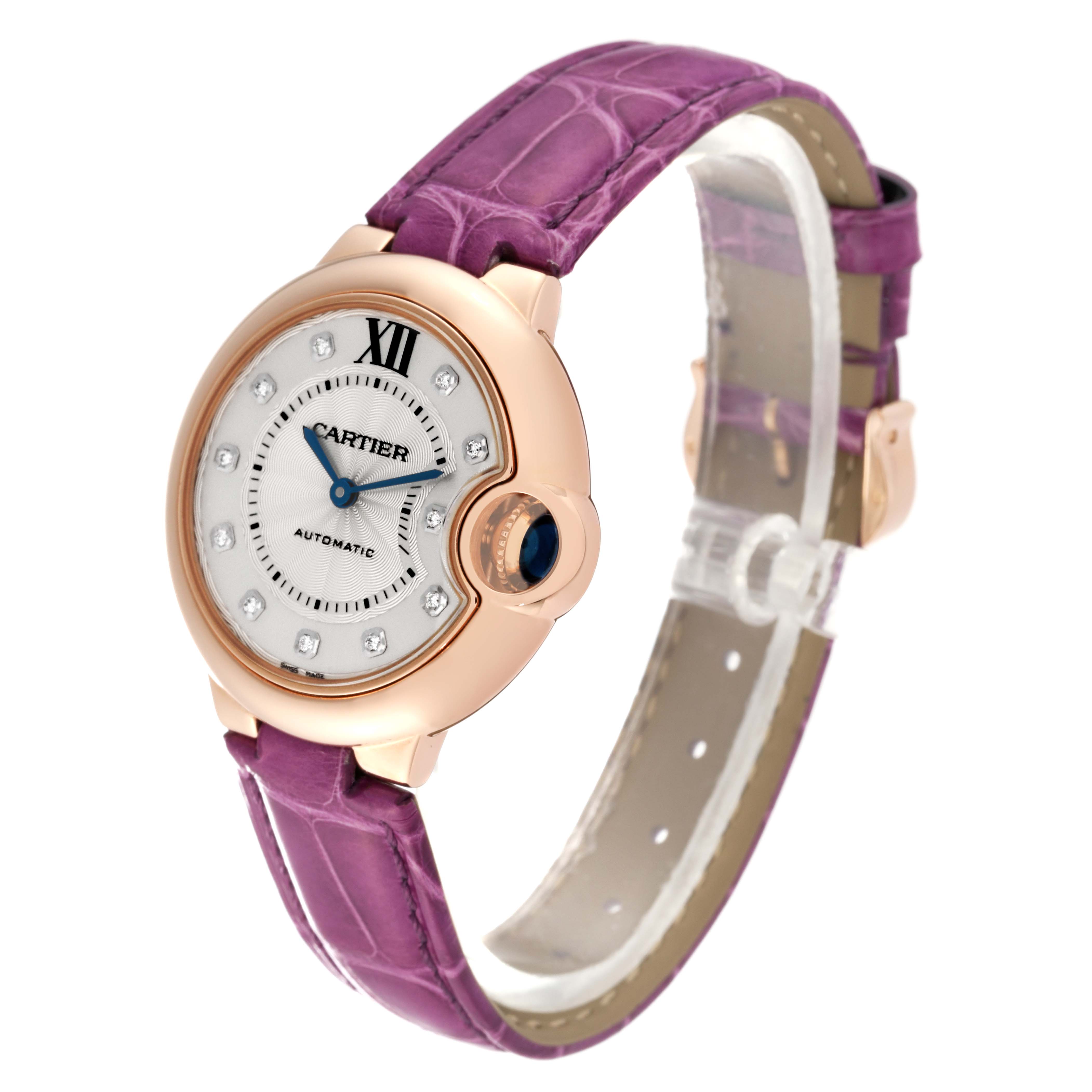 The Cartier Ballon Bleu WE902063 Women
s Rose Gold Silver Dial WE902063 Women
s Rose Gold Silver Dial watch is shown at a slight angle, highlighting its face, case, and purple alligator leather strap.