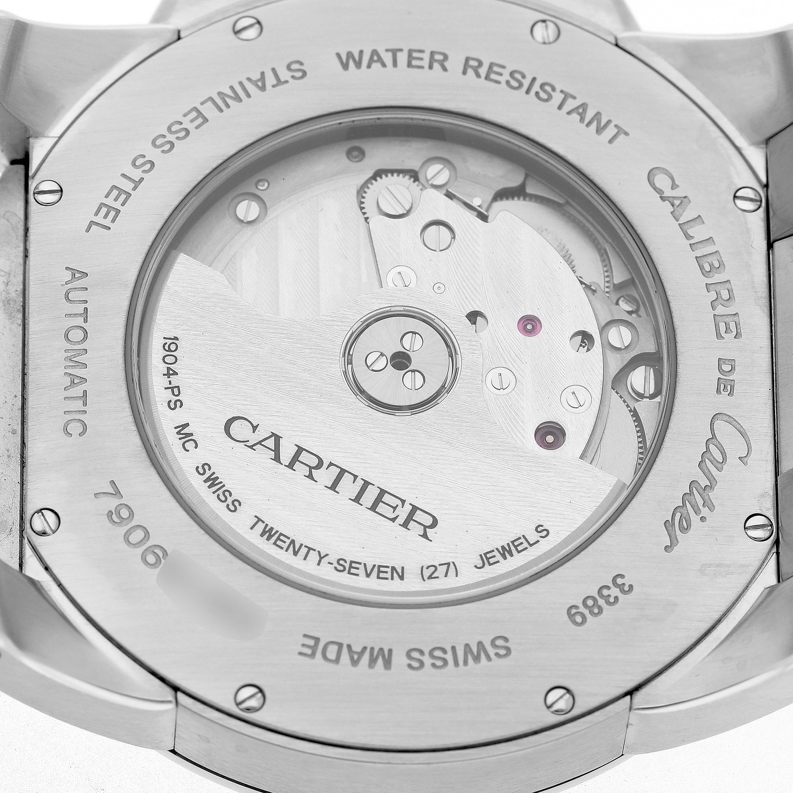 The image shows the back of the Calibre de Cartier watch, highlighting its automatic movement and engravings.