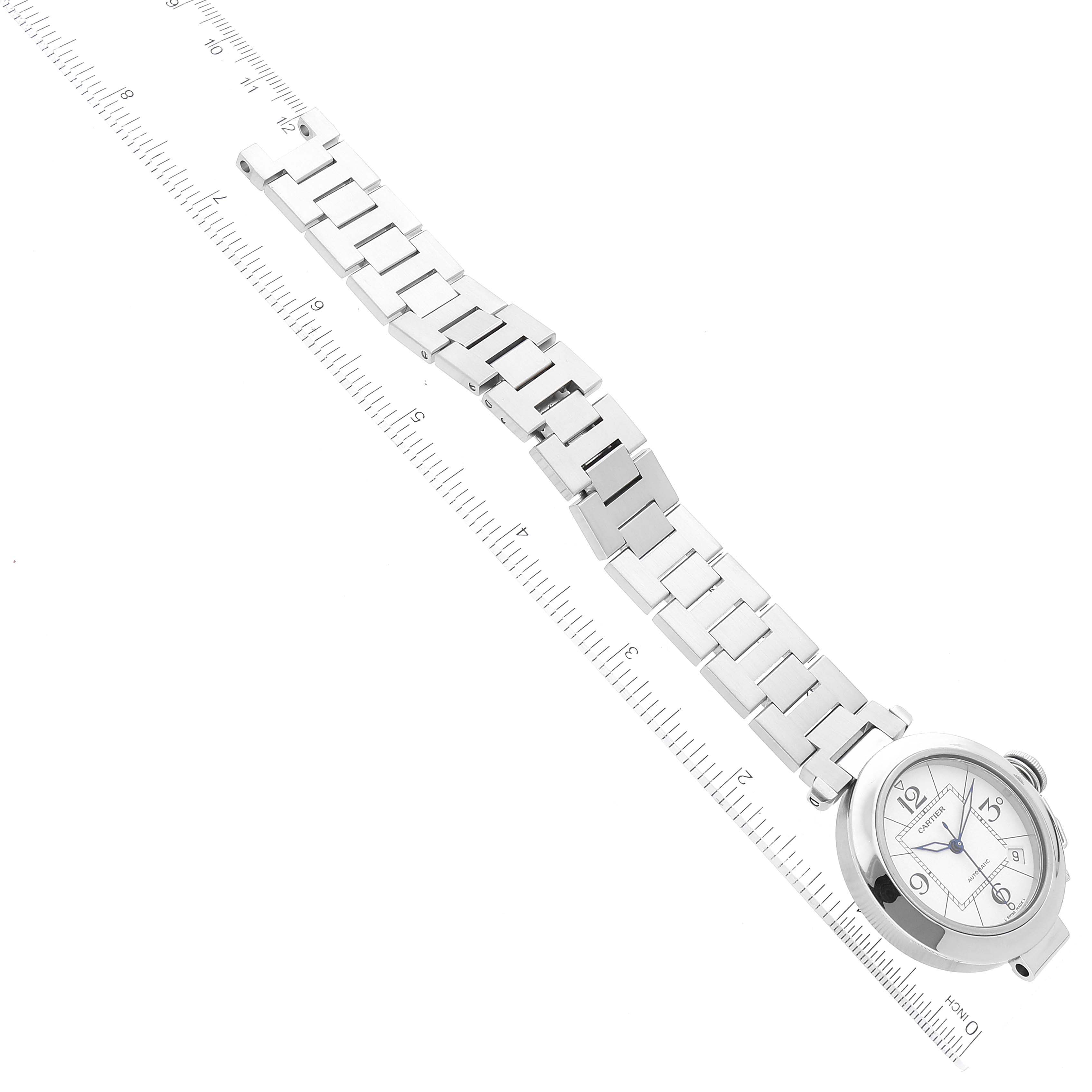 The image shows the full length of a Cartier Pasha W31074M7 Men's Stainless Steel White Dial W31074M7 Men's Stainless Steel White Dial watch, including its face and metal bracelet, aligned beside a ruler.