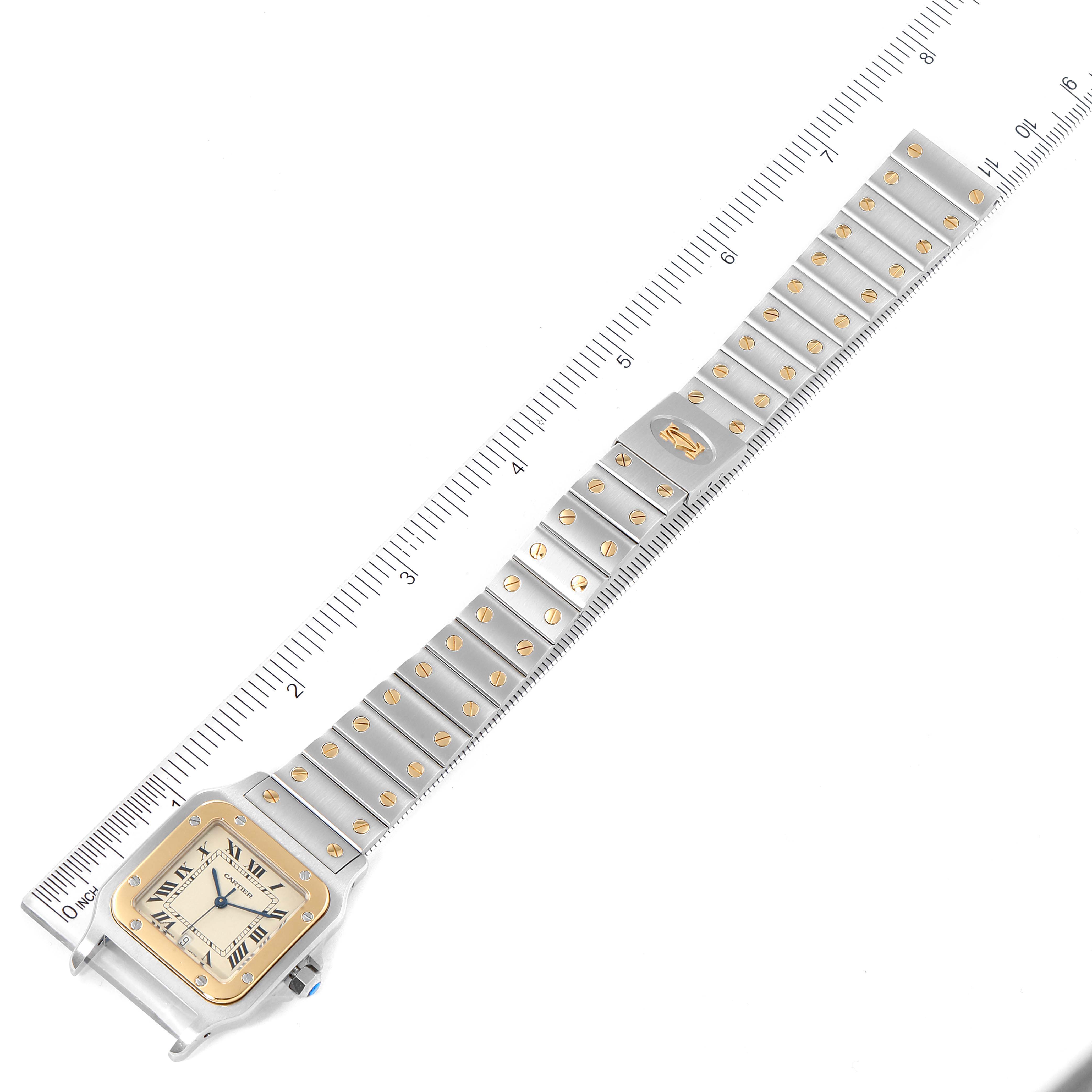 The image shows a Cartier Santos 1566 Men
s Steel and Gold (two tone) Silver Dial 1566 Men
s Steel and Gold (two tone) Silver Dial watch laid flat with its entire strap extended, alongside a measurement ruler for scale.