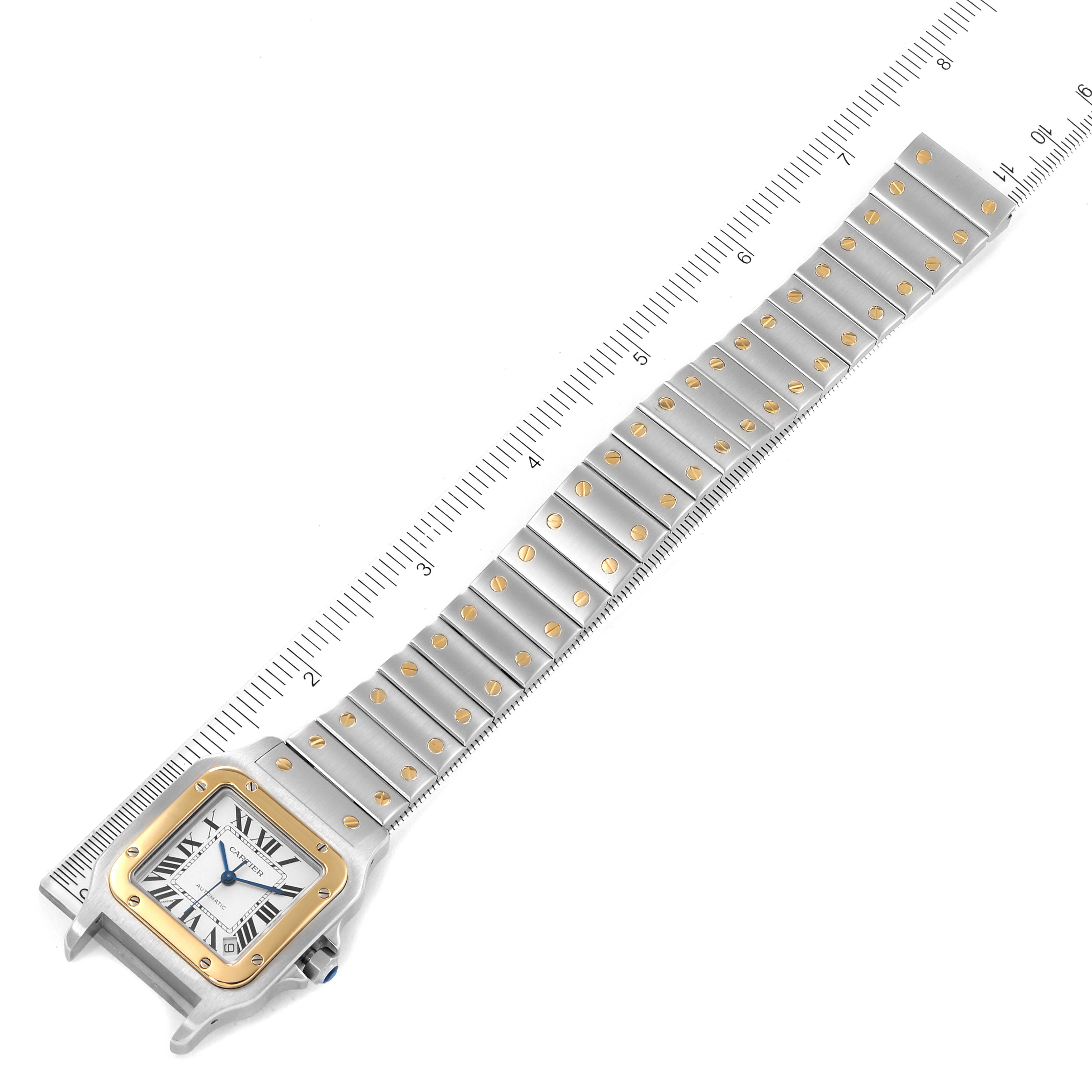 The image displays the face and band of a Cartier Santos W20099C4 Women's Steel and Gold (two tone) Silver Dial W20099C4 Women's Steel and Gold (two tone) Silver Dial watch, viewed from the top and aligned against a ruler.