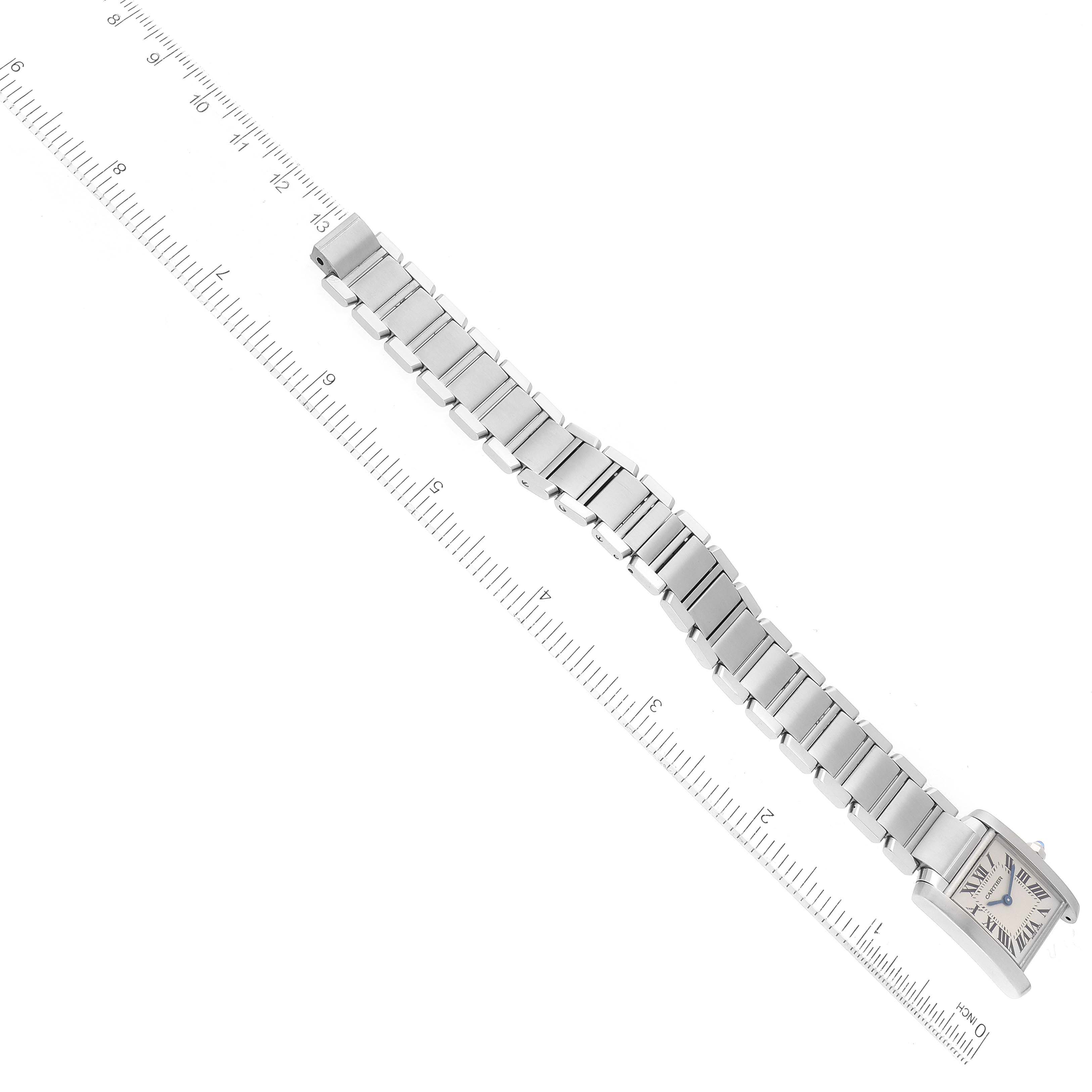 The image shows the entire Cartier Tank Française watch laid flat with a ruler for scale.