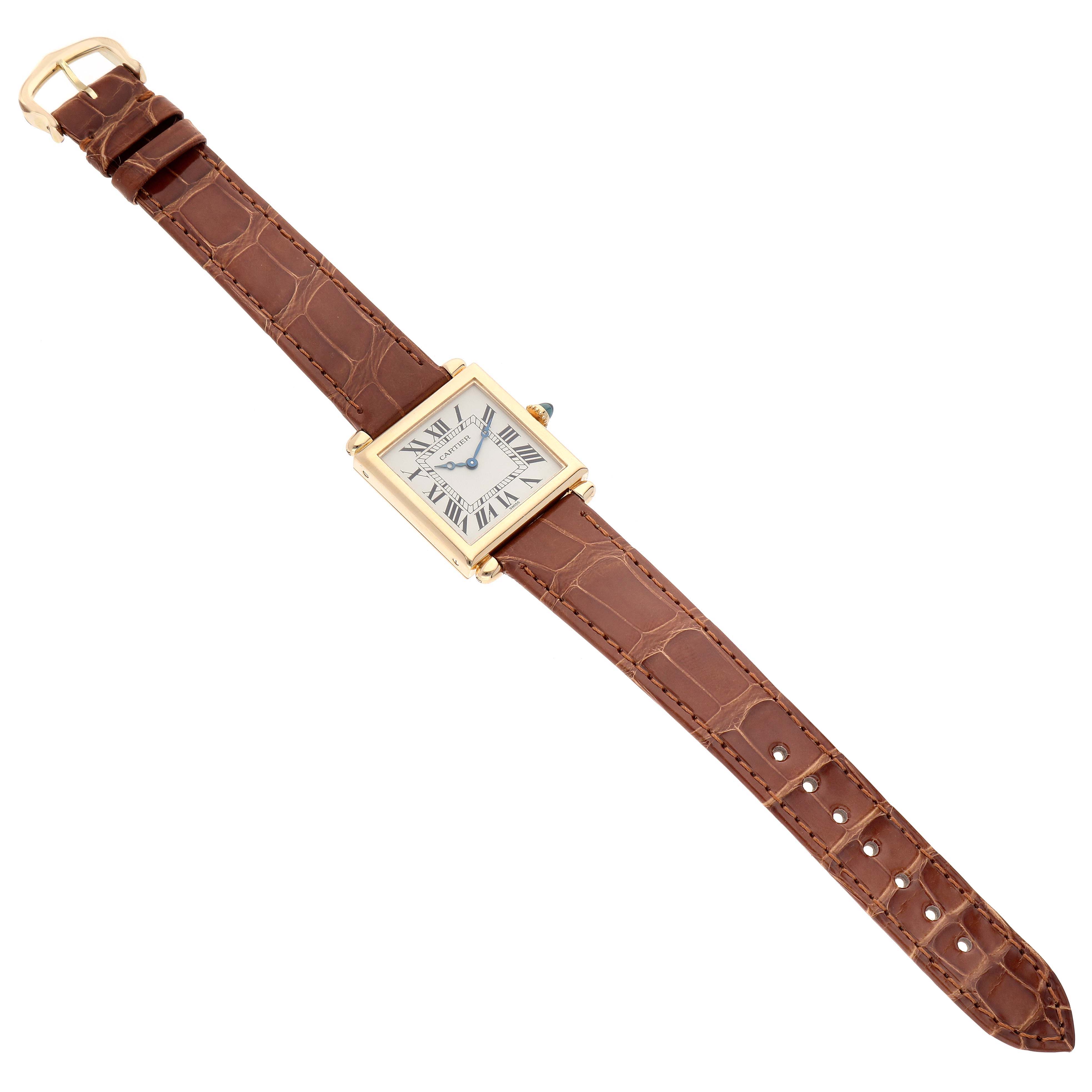 The Cartier Tank Obus W1512256 Women's Yellow Gold Silver Dial W1512256 Women's Yellow Gold Silver Dial watch is shown from a top-down angle, displaying the entire watch with a brown leather strap and rectangular face.