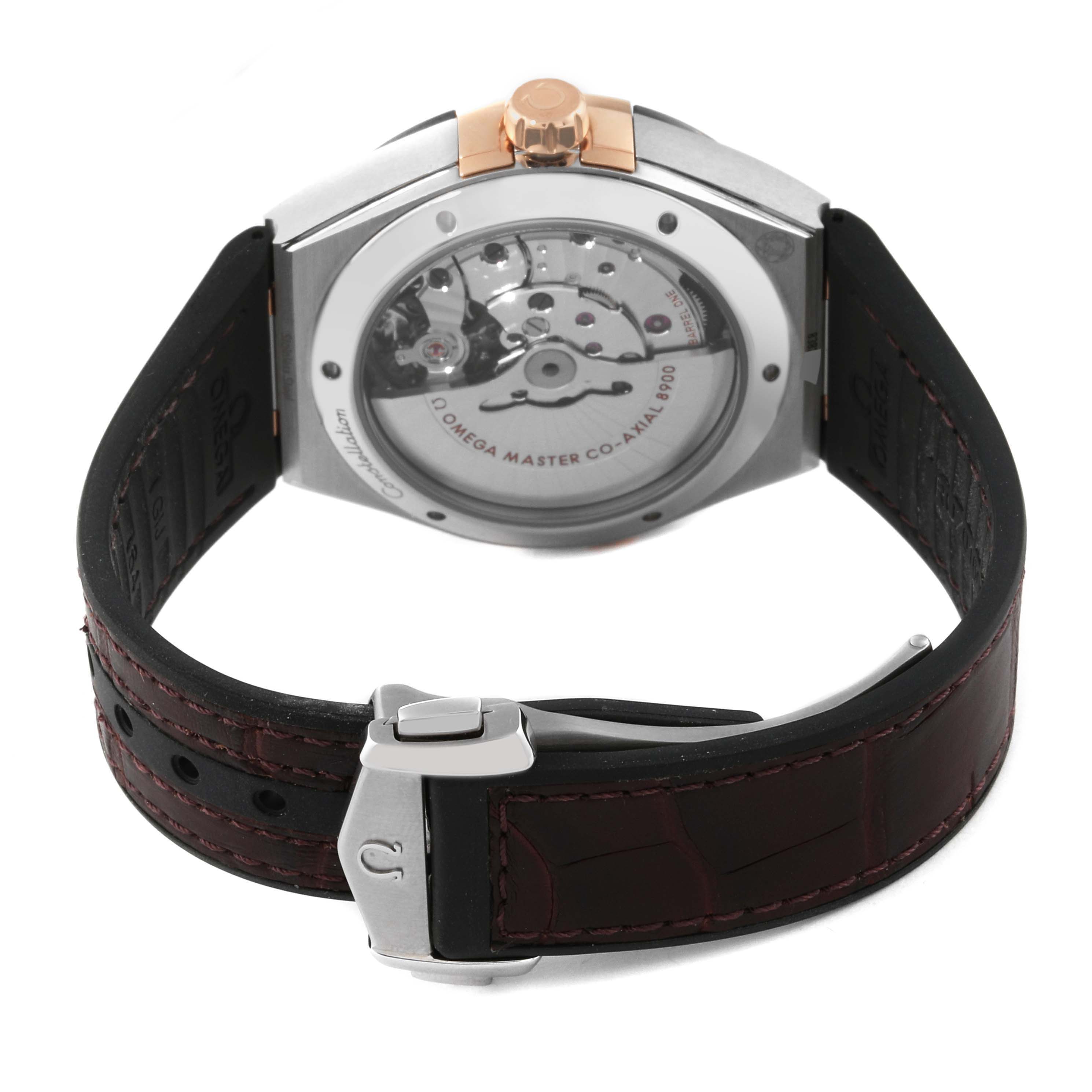 The image shows the back of an Omega Constellation 131.23.41.21.11.001 Men
s Steel and Gold (two tone) Red Dial 131.23.41.21.11.001 Men
s Steel and Gold (two tone) Red Dial watch, highlighting its movement and leather strap.