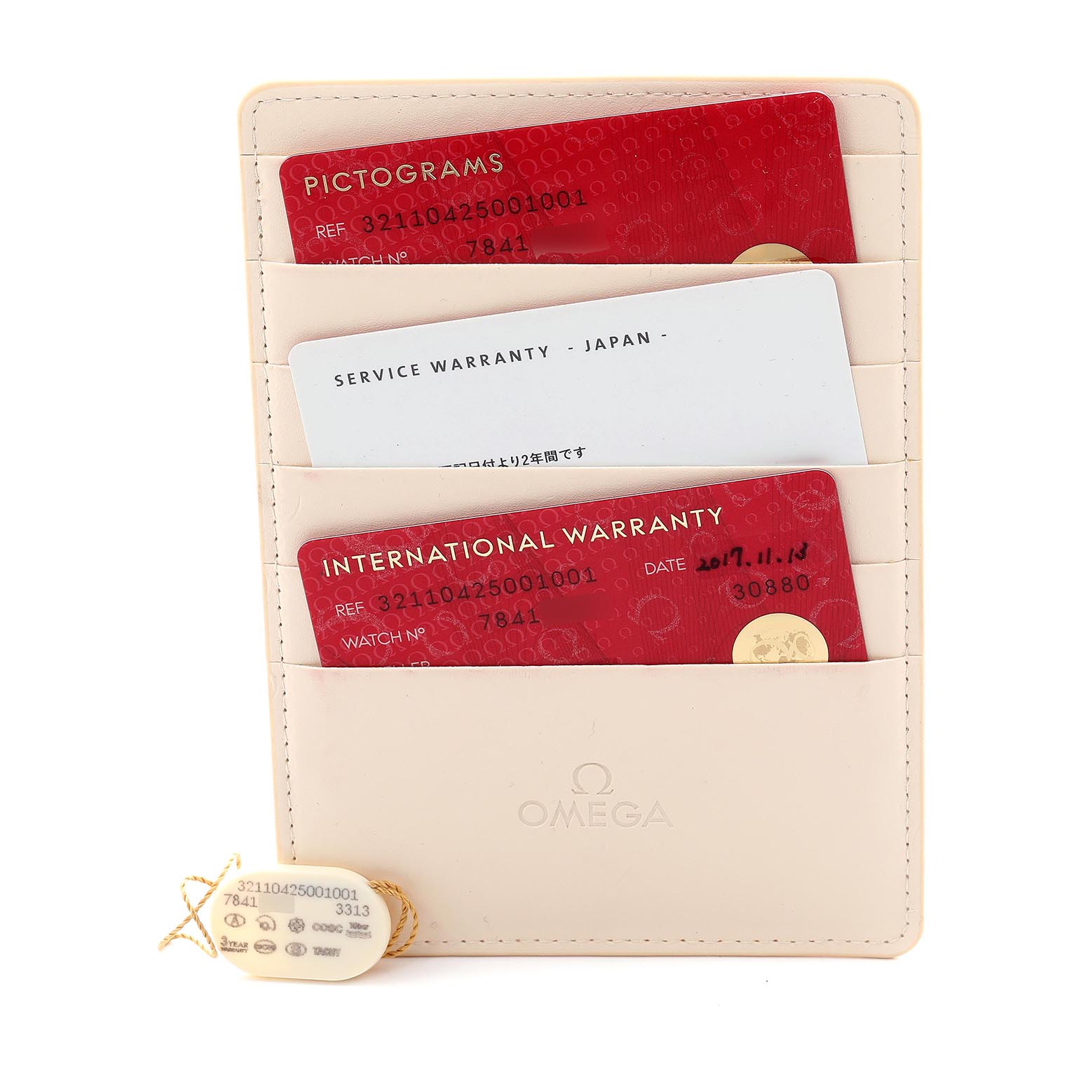 The image shows Omega Speedmaster 321.10.42.50.01.001 Men's Stainless Steel Black Dial 321.10.42.50.01.001 Men's Stainless Steel Black Dial model warranty cards and a cream cardholder with tags.