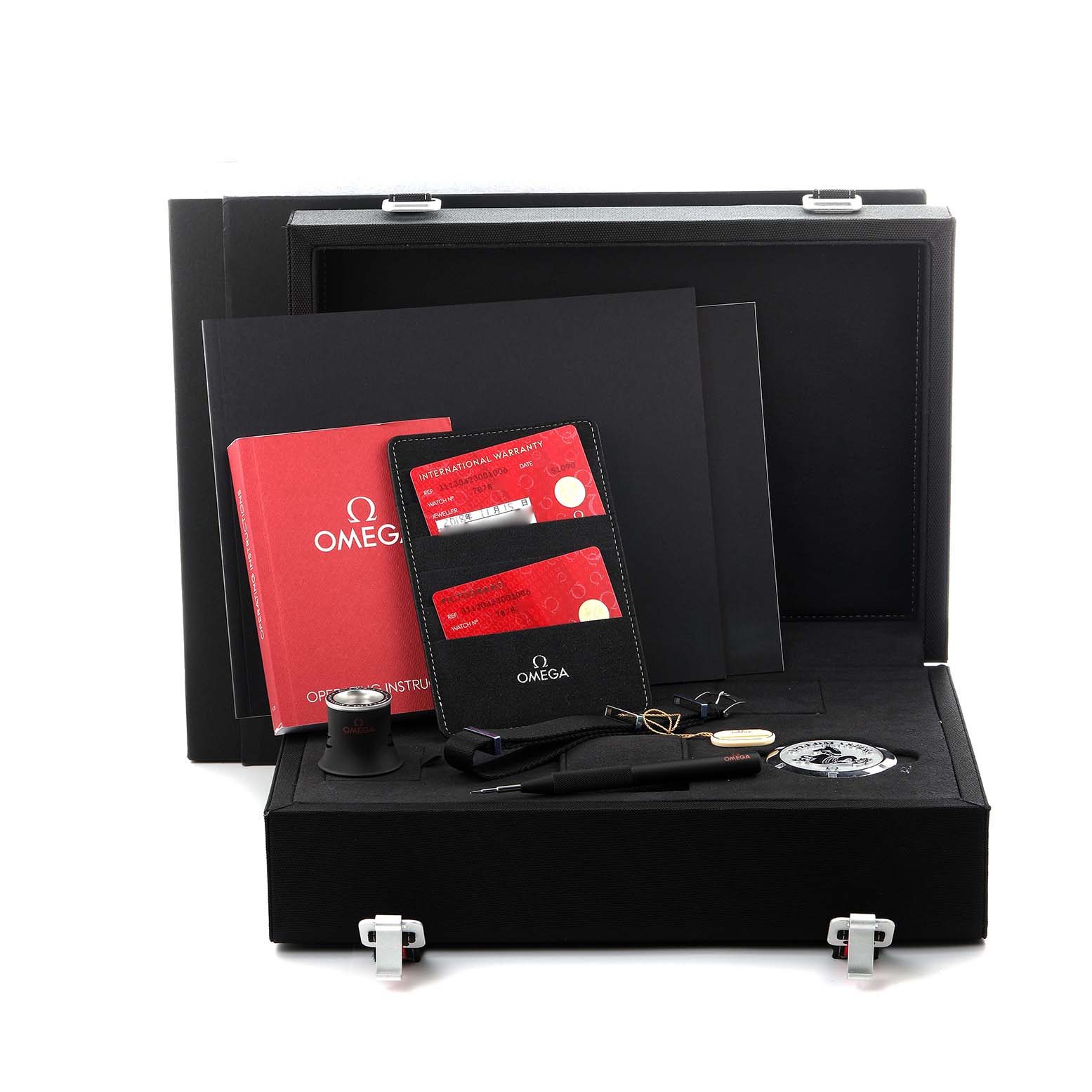 The Omega Speedmaster 311.30.42.30.01.006 Men's Stainless Steel Black Dial 311.30.42.30.01.006 Men's Stainless Steel Black Dial set is shown in an open case, including warranty cards, a loupe, a strap, a tool, and documentation.