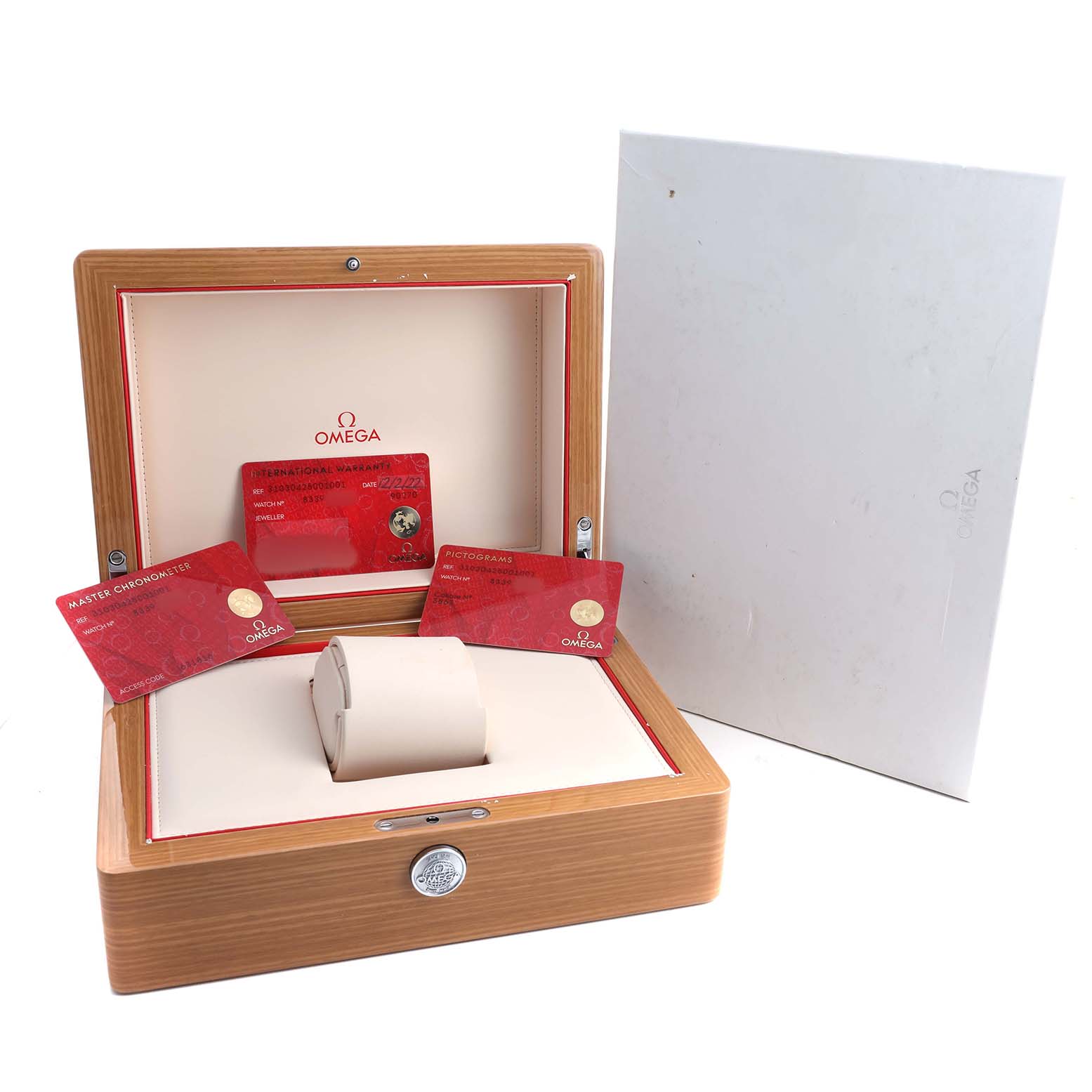 The image shows an Omega Speedmaster 310.30.42.50.01.001 Men's Stainless Steel Black Dial watch box with accessories, including cards and a cushion, displayed open from the front.