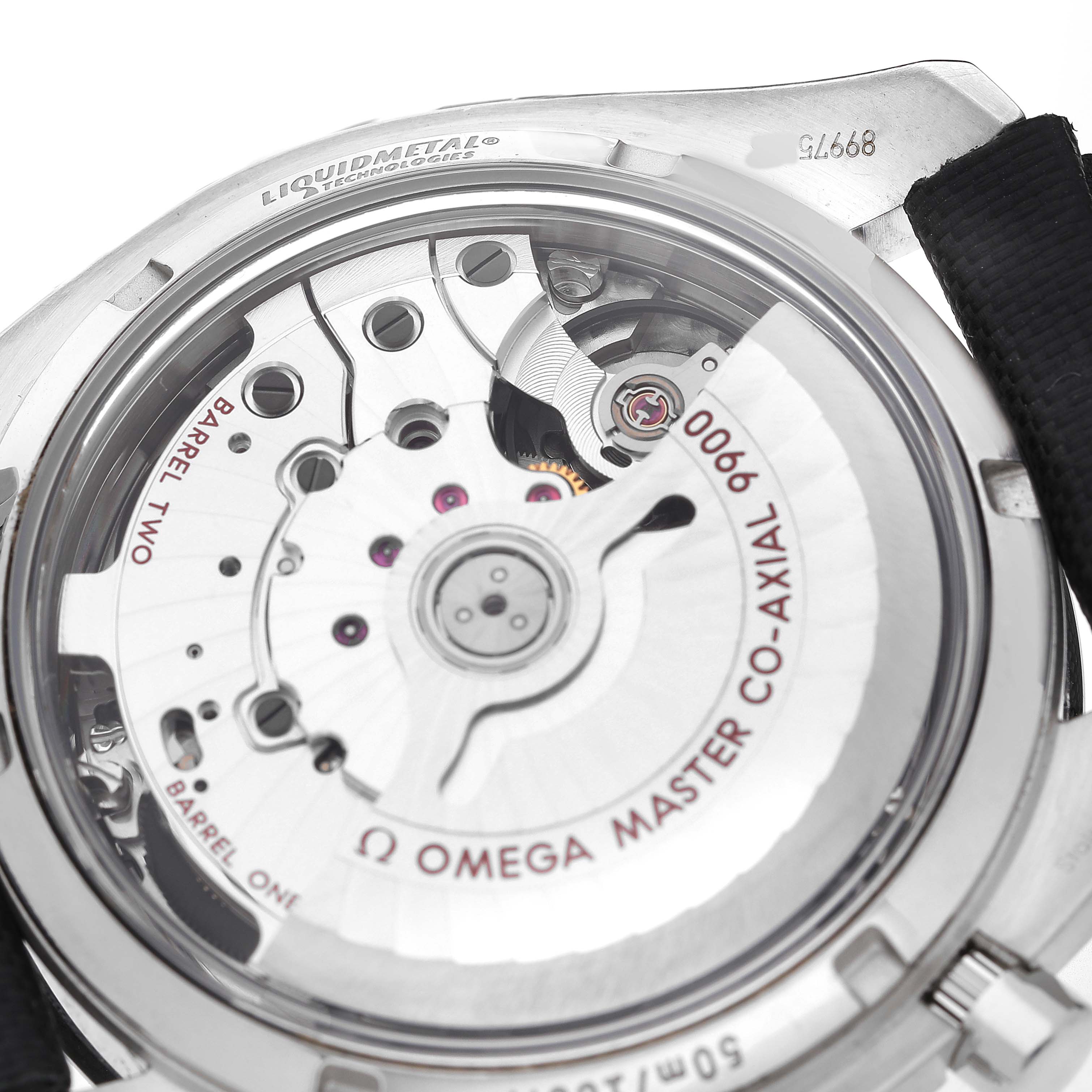 The image shows the back view of the Omega Speedmaster 329.32.44.51.01.001 Men's Stainless Steel Black Dial, highlighting its Co-Axial 9900 movement and internal mechanisms.