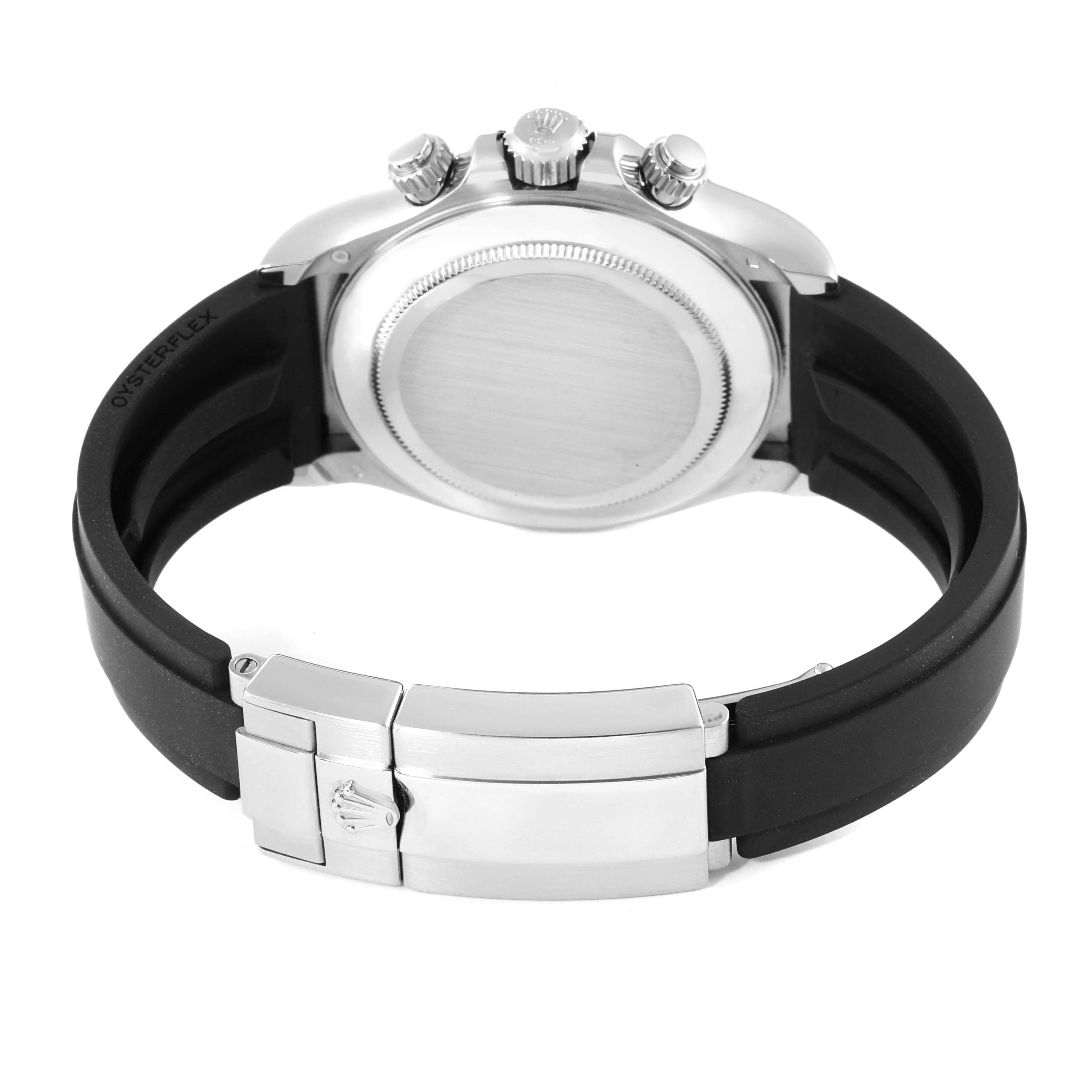 The image shows the back view of a Rolex Daytona 116519 Men
s White Gold Black Dial 116519 Men
s White Gold Black Dial watch, highlighting its case back, crown, pushers, and Oysterflex strap with a clasp.