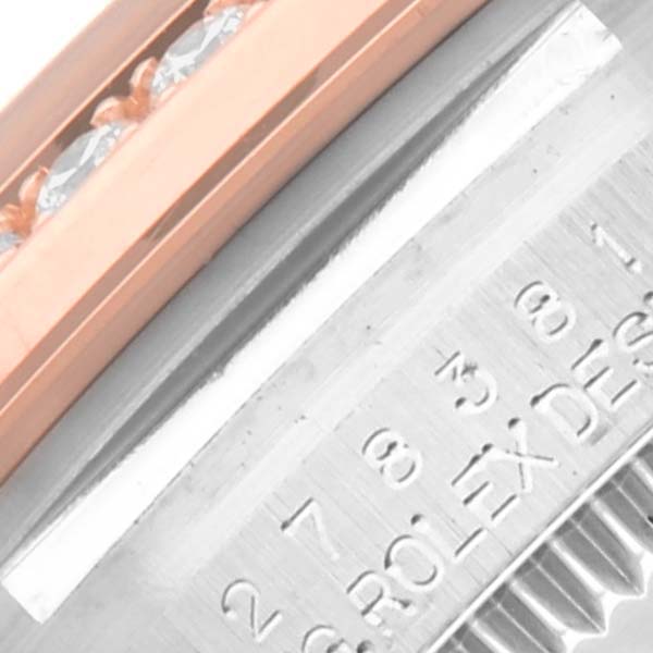 The image shows a close-up angle of a Rolex Mid-Size 278381 Women's Steel and Gold (two tone) Pink Dial 278381 Women's Steel and Gold (two tone) Pink Dial watch, highlighting the bezel with embedded diamonds and part of the engraved case.