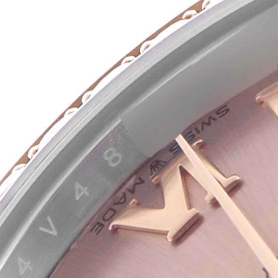 The image shows a close-up of a Rolex Mid-Size 278381 Women's Steel and Gold (two tone) Pink Dial 278381 Women's Steel and Gold (two tone) Pink Dial watch, focusing on the partial view of the bezel and dial's edge with Roman numerals.