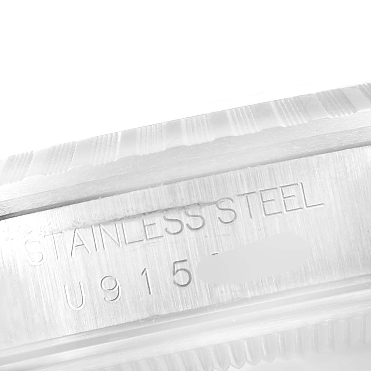 The image shows a close-up of the etched serial number and "STAINLESS STEEL" on the side of a Rolex Datejust 16220 Men
s Stainless Steel Pink Dial 16220 Men
s Stainless Steel Pink Dial watch case.