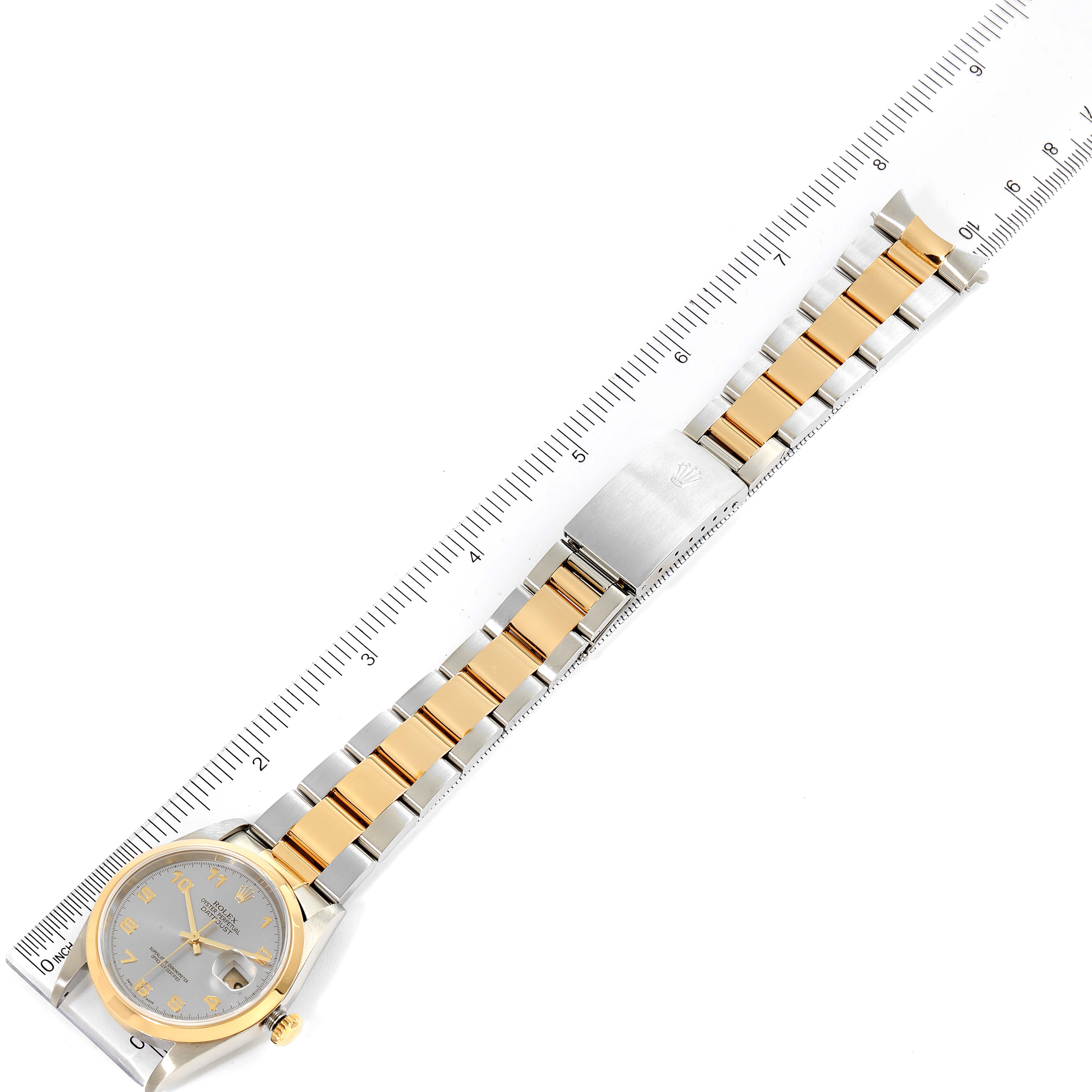 This image shows a Rolex Datejust 16203 Men's Steel and Gold (two tone) Grey Dial 16203 Men's Steel and Gold (two tone) Grey Dial watch displayed flat alongside a ruler, highlighting the watch's face, bezel, and two-tone bracelet.