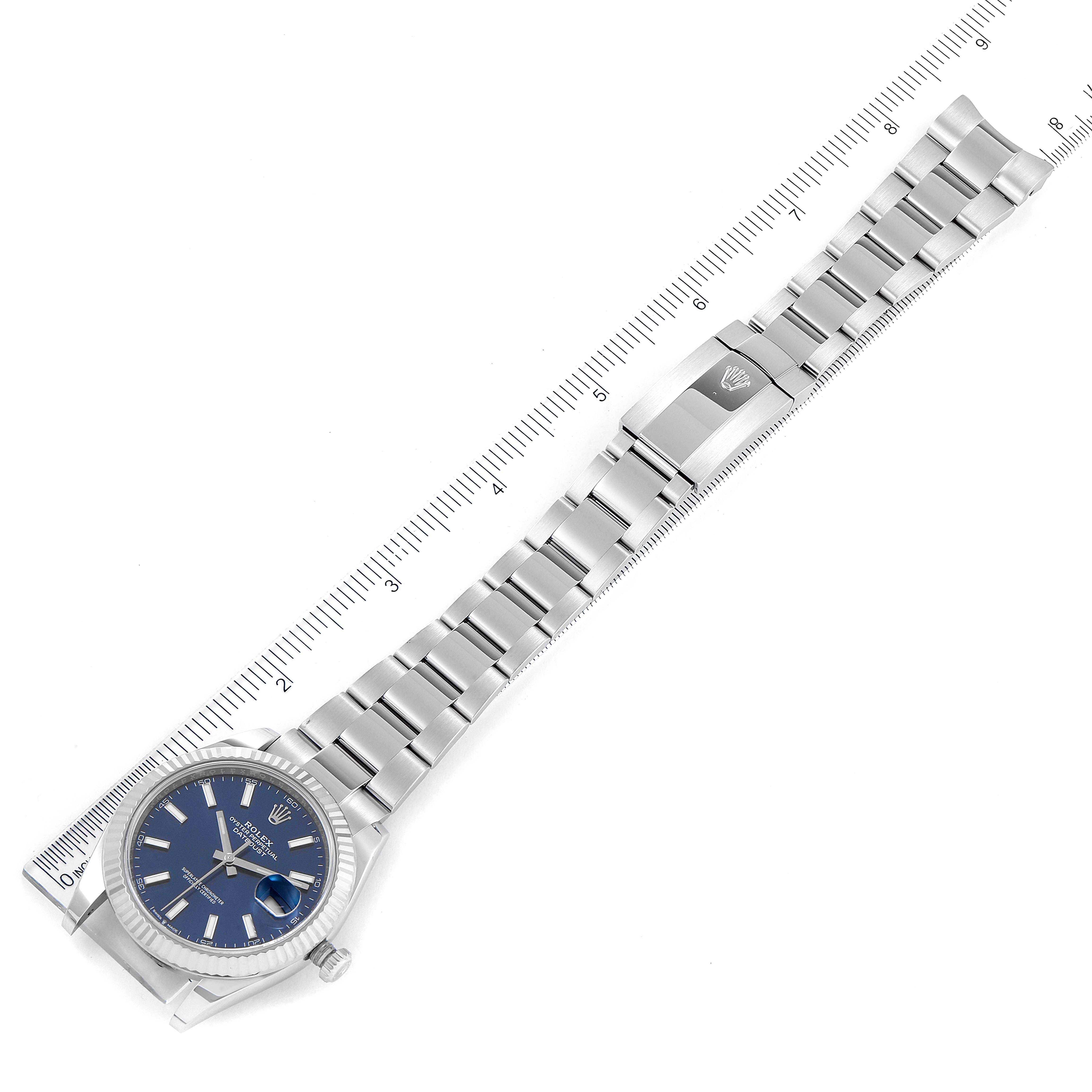 The image shows a top-down view of the Rolex Datejust 41 126334 Men
s Stainless Steel Blue Dial 126334 Men
s Stainless Steel Blue Dial watch with a blue dial and full bracelet, alongside a ruler for scale.