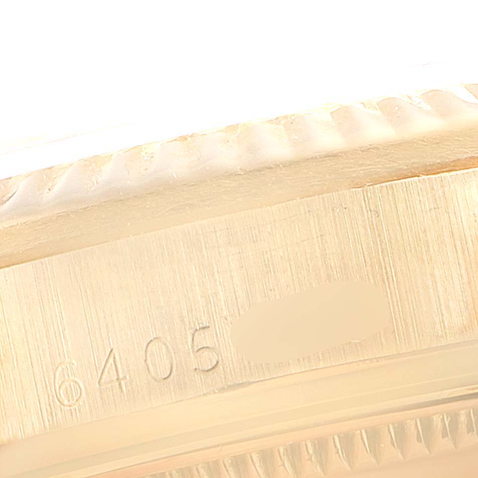 This is a close-up shot showing the serial number and part of the bezel of the Rolex President 6827 Women's Yellow Gold White Dial 6827 Women's Yellow Gold White Dial model watch.