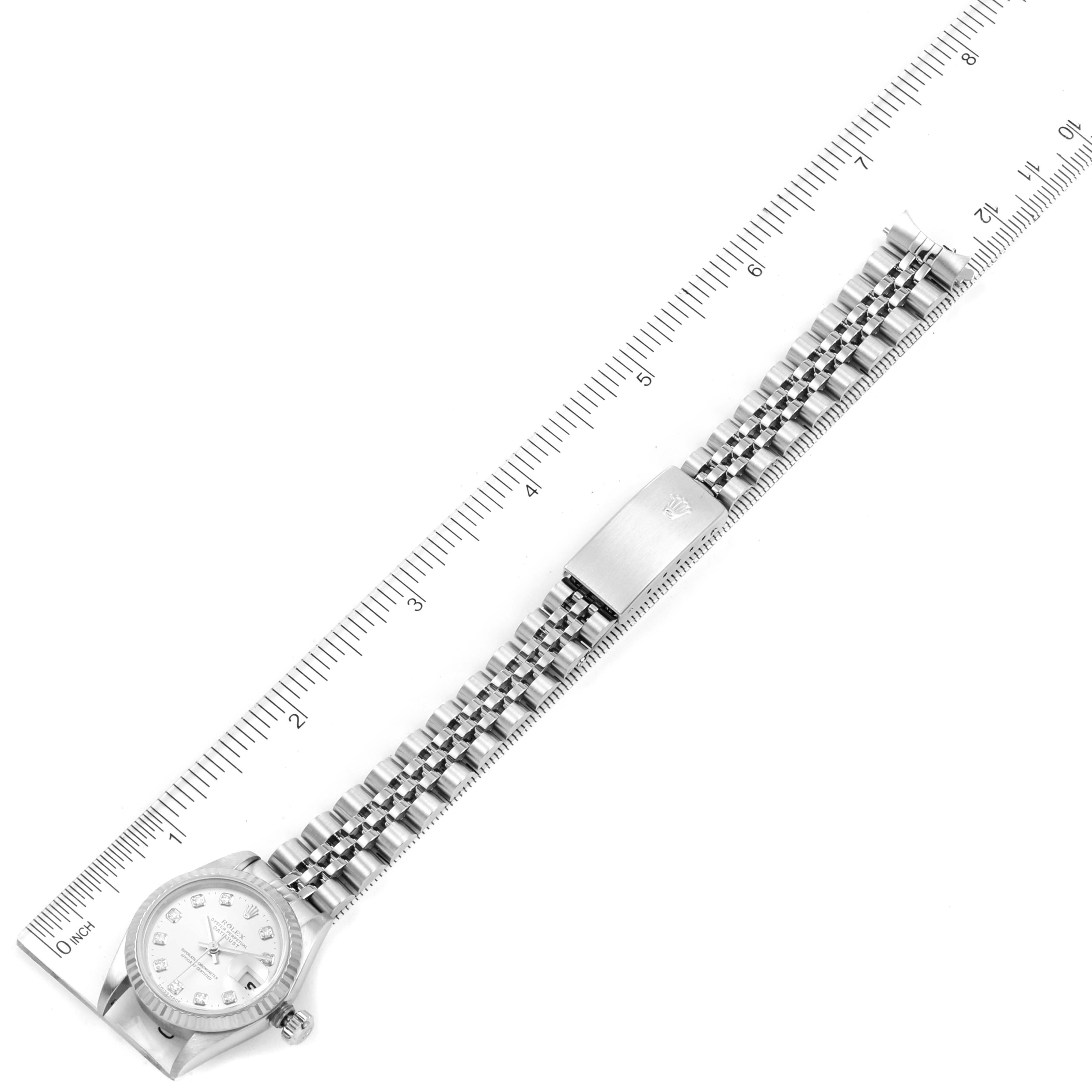 The image shows a top view of a Datejust Rolex watch, displaying the watch face, bracelet, and clasp against a ruler.