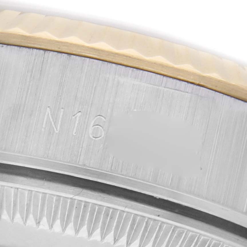 The image shows a close-up of the side of a Rolex Datejust 69173 Women
s Steel and Gold (two tone) Champagne Dial 69173 Women
s Steel and Gold (two tone) Champagne Dial, featuring the fluted bezel and engraved details.