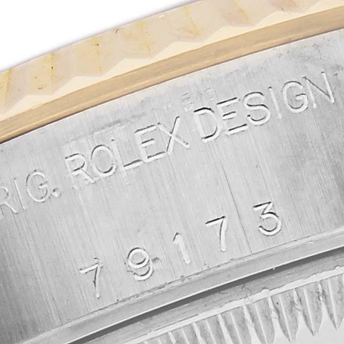The image shows a close-up of the side of a Rolex Datejust 79173 Women's Steel and Gold (two tone) Champagne Dial 79173 Women's Steel and Gold (two tone) Champagne Dial watch, focusing on the engraved serial number and design details.