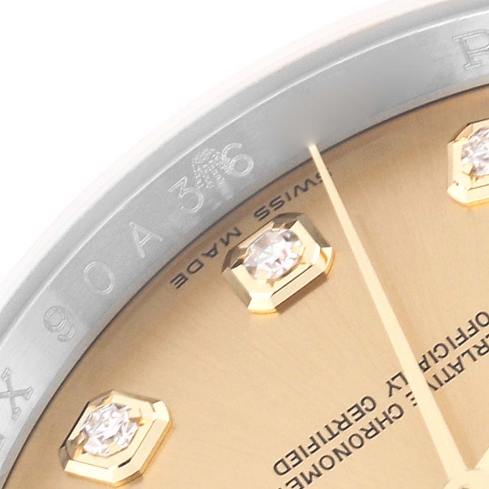 This close-up angle of the Rolex Datejust 116233 Men's Steel and Gold (two tone) Champagne Dial 116233 Men's Steel and Gold (two tone) Champagne Dial watch shows part of the dial, diamond markers, and the inner bezel with engraved text.