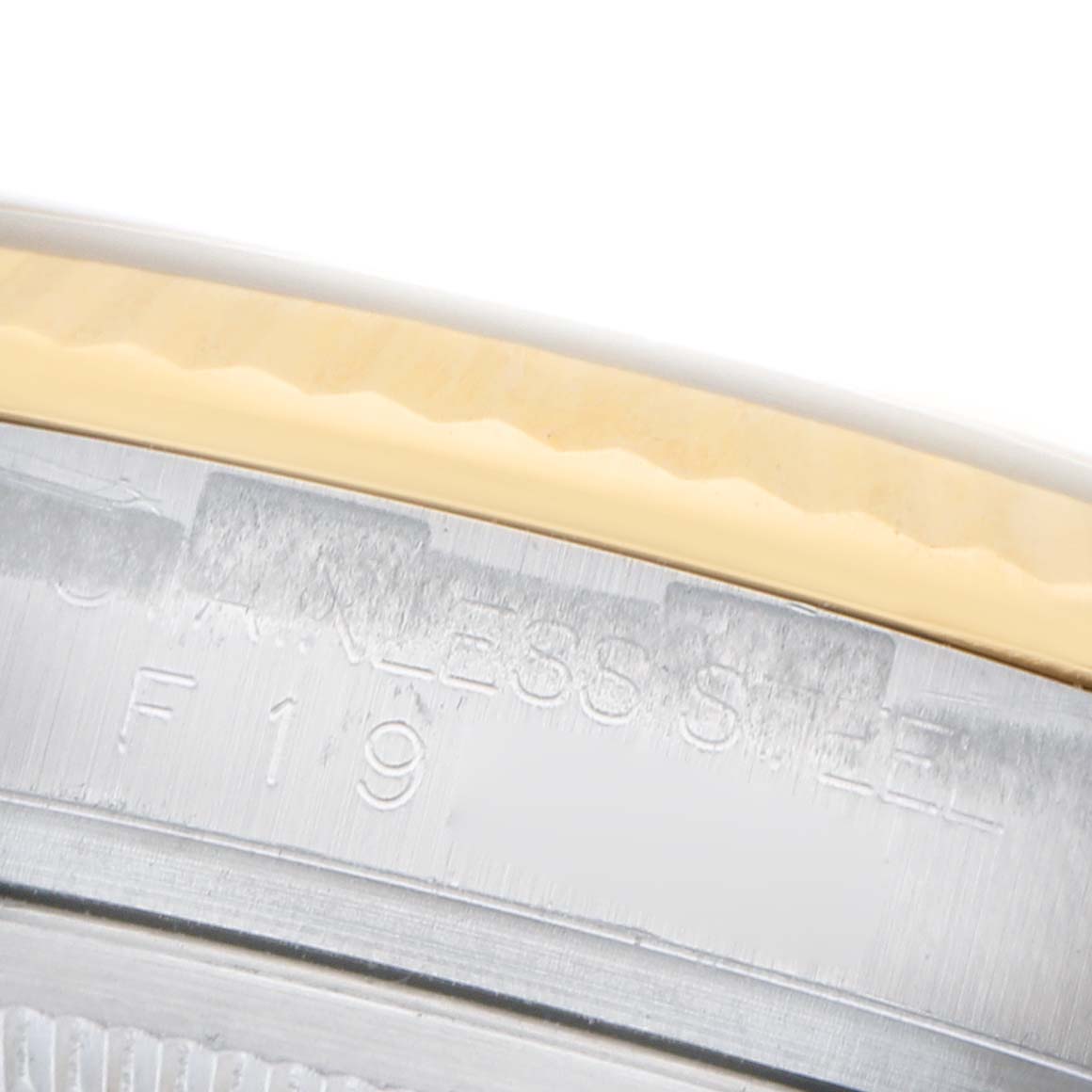 The image shows a close-up of the bezel and case edge of a Rolex Datejust 116233 Women's Steel and Gold (two tone) Champagne Dial, highlighting its stainless steel and gold materials.