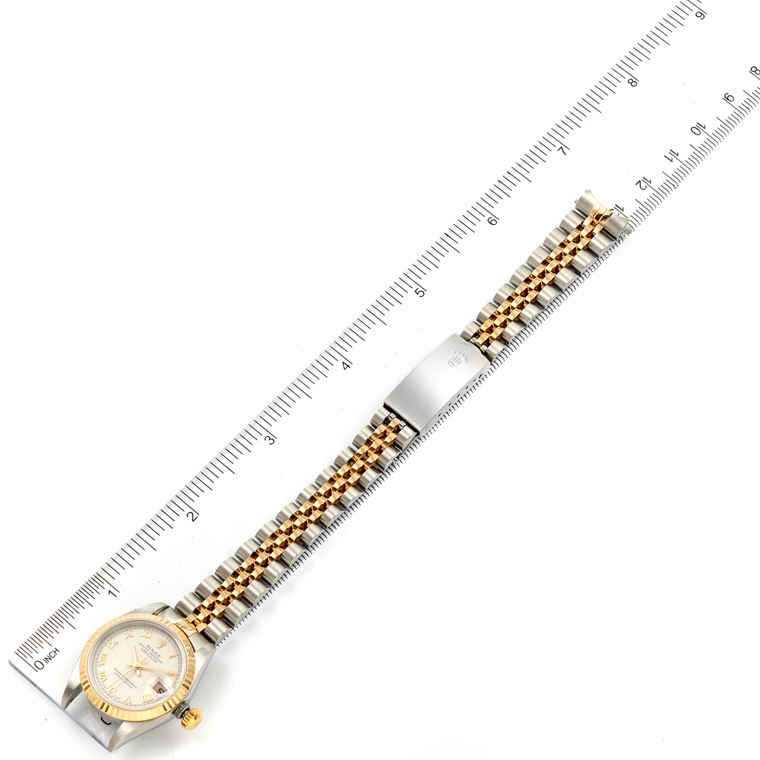 This image shows a Rolex Datejust 79173 Women's Steel and Gold (two tone) Beige Dial 79173 Women's Steel and Gold (two tone) Beige Dial watch laid flat next to a ruler to measure its full length.