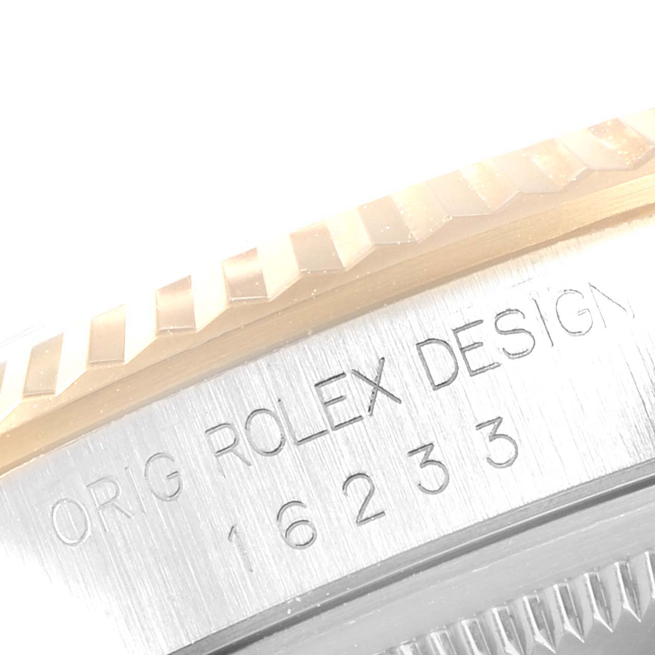 This close-up image of a Rolex Datejust 16233 Men
s Steel and Gold (two tone) White Dial 16233 Men
s Steel and Gold (two tone) White Dial watch shows the engraved model number and the edge of the fluted bezel.