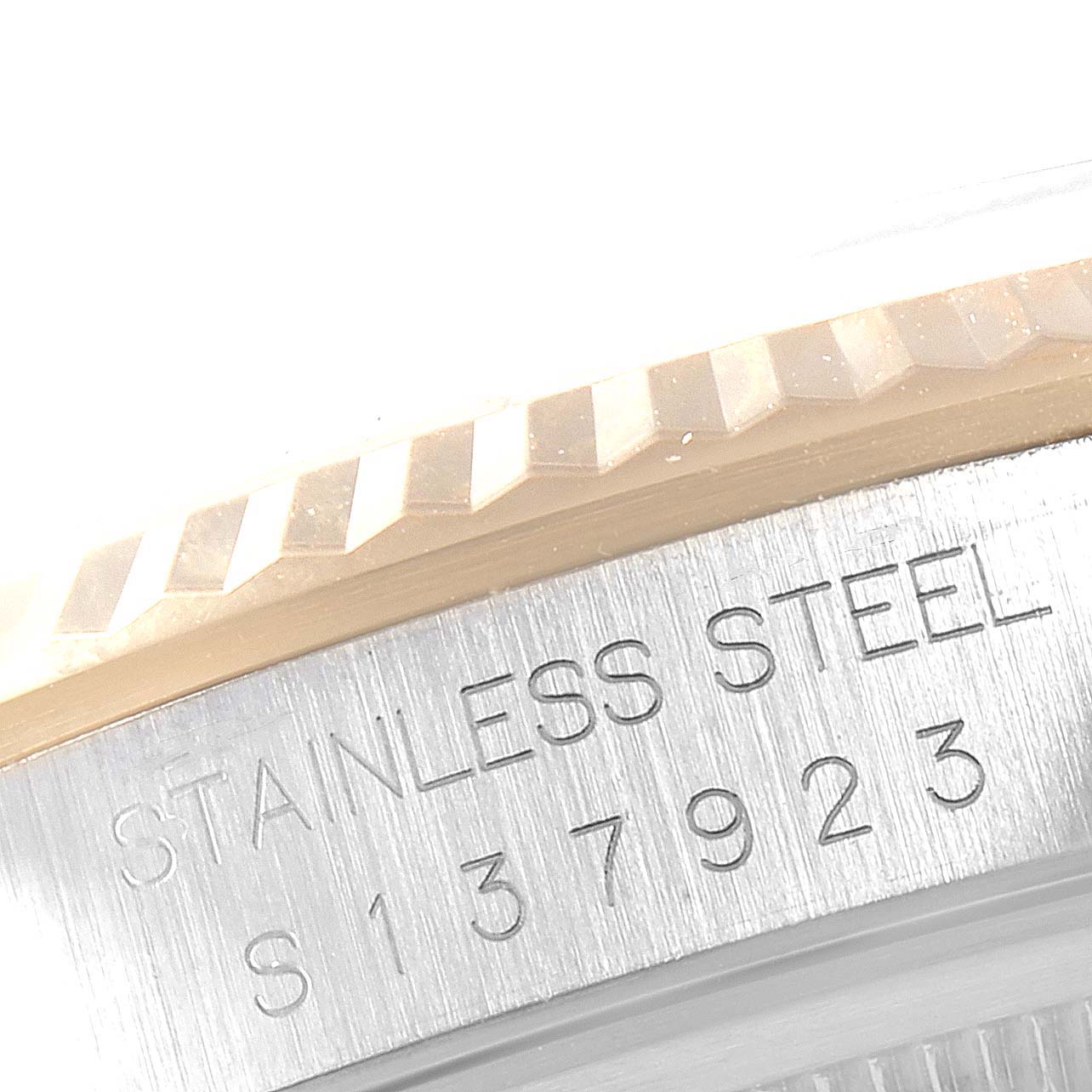 The image shows a close-up of the Rolex Datejust 16233 Men
s Steel and Gold (two tone) White Dial 16233 Men
s Steel and Gold (two tone) White Dial watch
s case, highlighting the fluted bezel and stainless steel engravings.