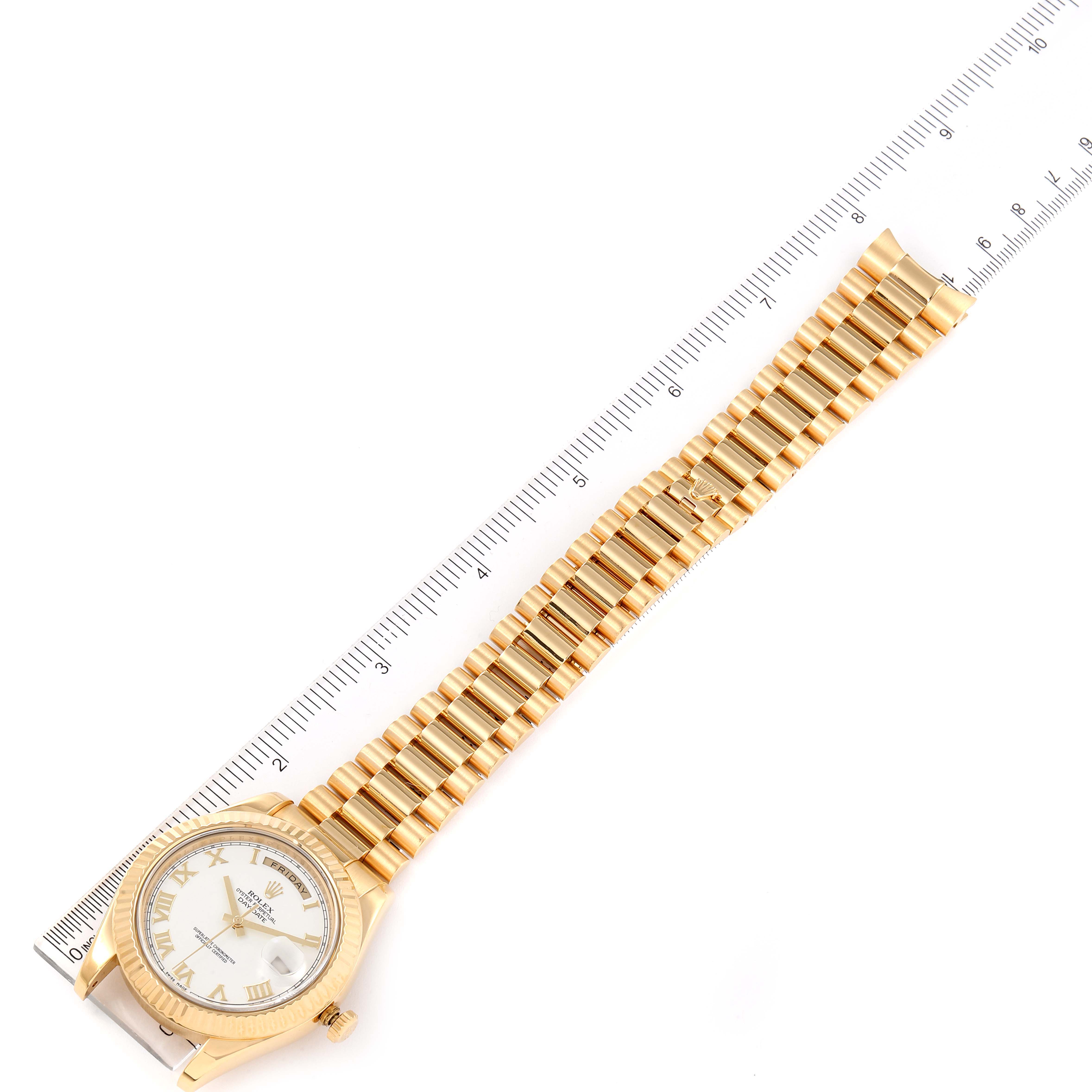 The image shows a Rolex President 218238 Men's Yellow Gold White Dial 218238 Men's Yellow Gold White Dial model watch lying flat next to a ruler, displaying its band and face.