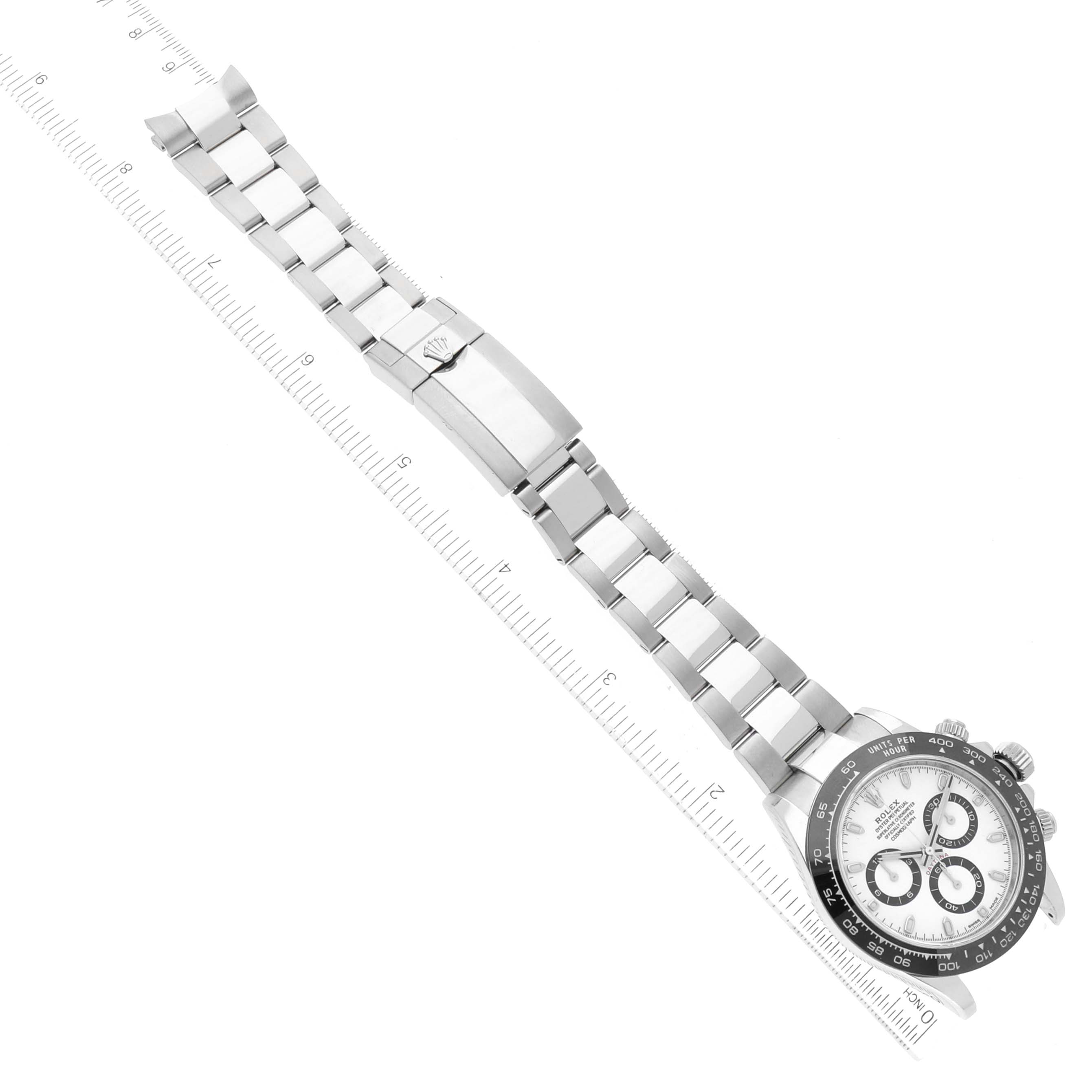 The image shows a Rolex Daytona 116500LN-0001 Men's Stainless Steel White Dial 116500LN-0001 Men's Stainless Steel White Dial watch placed diagonally with its bracelet extended and measured against a ruler.